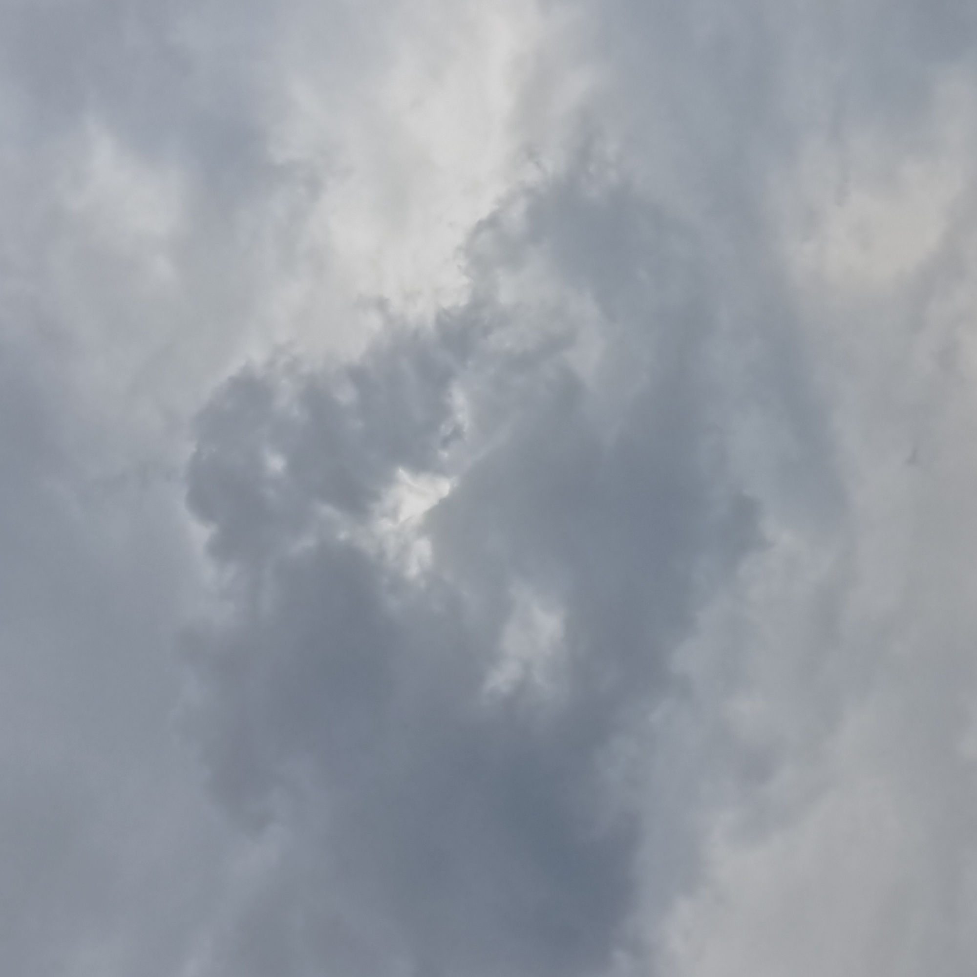 The image depicts a cloudy sky, with varying shades of gray and white. The clouds are dense and appear to be layered, suggesting overcast conditions. There are no discernible landmarks or objects within the frame, indicating a focus solely on the atmospheric conditions. The image does not provide any information about the location in the city of Irgeil' rural district, Kazakhstan, or any specific details about people, subjects, objects, actions, or interactions. It is purely a sky-scape.