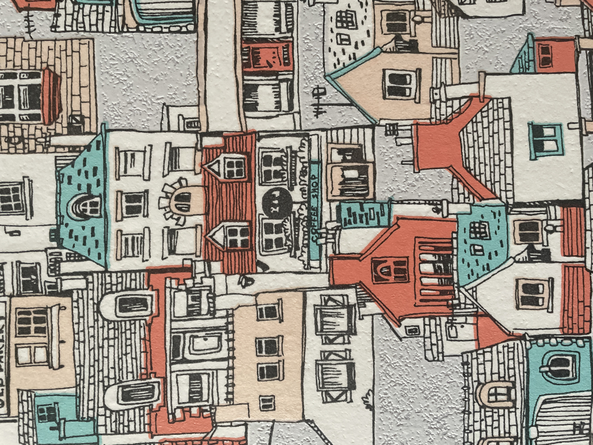 The image is a close-up, flat-lay, eye-level, full shot of a decorative pattern featuring an intricate illustration of a European-style village or town. The buildings are rendered in a simplified, hand-drawn style with thick black outlines and filled with various colors including white, peach, light blue, and coral red. The architectural details include pitched roofs, chimneys, various window shapes, doors, and some signs indicating businesses like "OLD BAKERY" and "COFFEE SHOP." The background is a textured gray, simulating a stone or stucco wall. The scene is densely packed with overlapping buildings, creating a sense of a crowded urban environment. There are no people or animals depicted in the illustration, and no identifiable landmarks suggest a specific location within Vologda, Russia. The image appears to be a section of wallpaper, fabric, or a print.