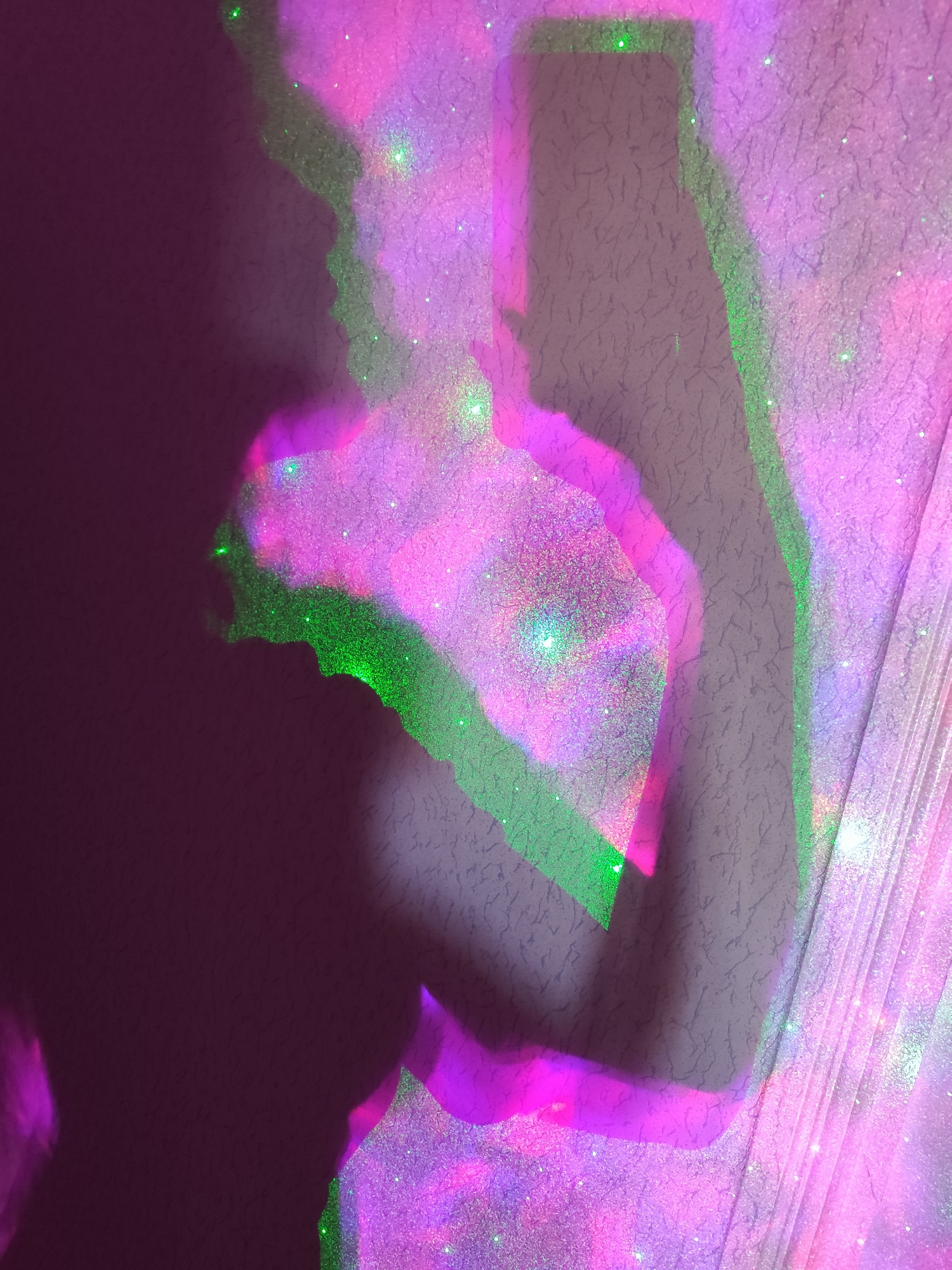 The image shows a shadow of a person on a wall. The wall has a textured surface. The shadow is illuminated with purple and green light. The background appears to be in a dimly lit room. There is no indication of the city of Фоки, Russia.