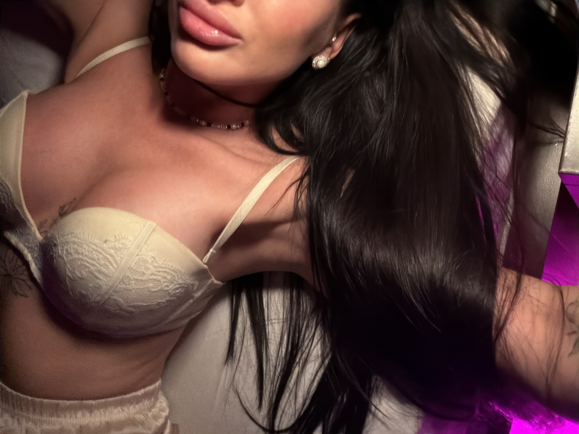 A woman is lying down wearing a white bra and shorts. She has long, dark hair and is wearing earrings and a necklace. The location is unspecified and the city of Boreti, Montenegro is not discernable from the image.