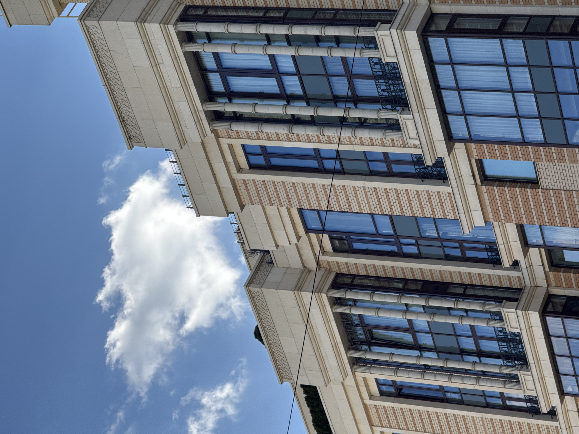 The image shows the exterior of a building with classic architectural details, including columns and decorative brickwork. The building has large windows and appears to be multi-story. The sky is visible with some clouds, suggesting it is daytime. The building appears to be located in Moscow, Russia.