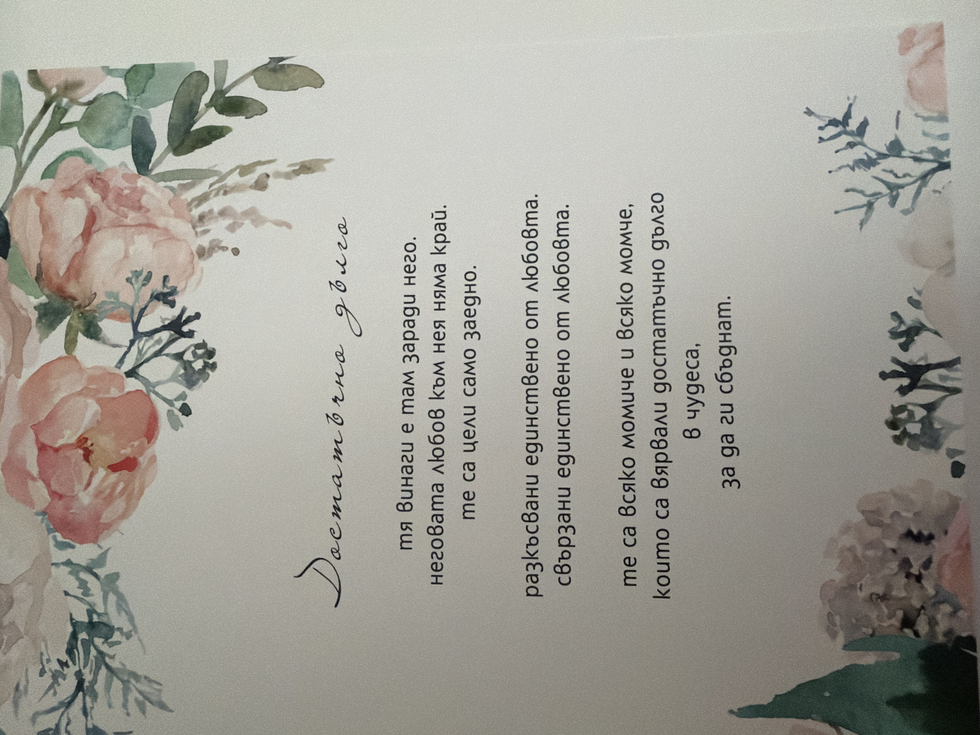The image is a close-up of a card or invitation with floral watercolor decorations at the top and bottom. The text is handwritten in a script font in black ink and is in Bulgarian.
The text reads:
"Достатъчно дълго
тя винаги е там заради него.
неговата любов към нея няма край.
те са цели само заедно.
разкъсвани единствено от любовта.
свързани единствено от любовта.
те са всяко момиче и всяко момче,
които са вярвали достатъчно дълго
в чудеса,
за да ги сбъднат."
Translation:
"Long enough
she is always there for him.
her love for him knows no end.
they are whole only together.
torn apart only by love.
bound together only by love.
they are every girl and every boy,
who believed long enough
in miracles,
to make them come true."
There is no indication of a location in Pazardzhik, Bulgaria. The image is a still photograph of a printed item.