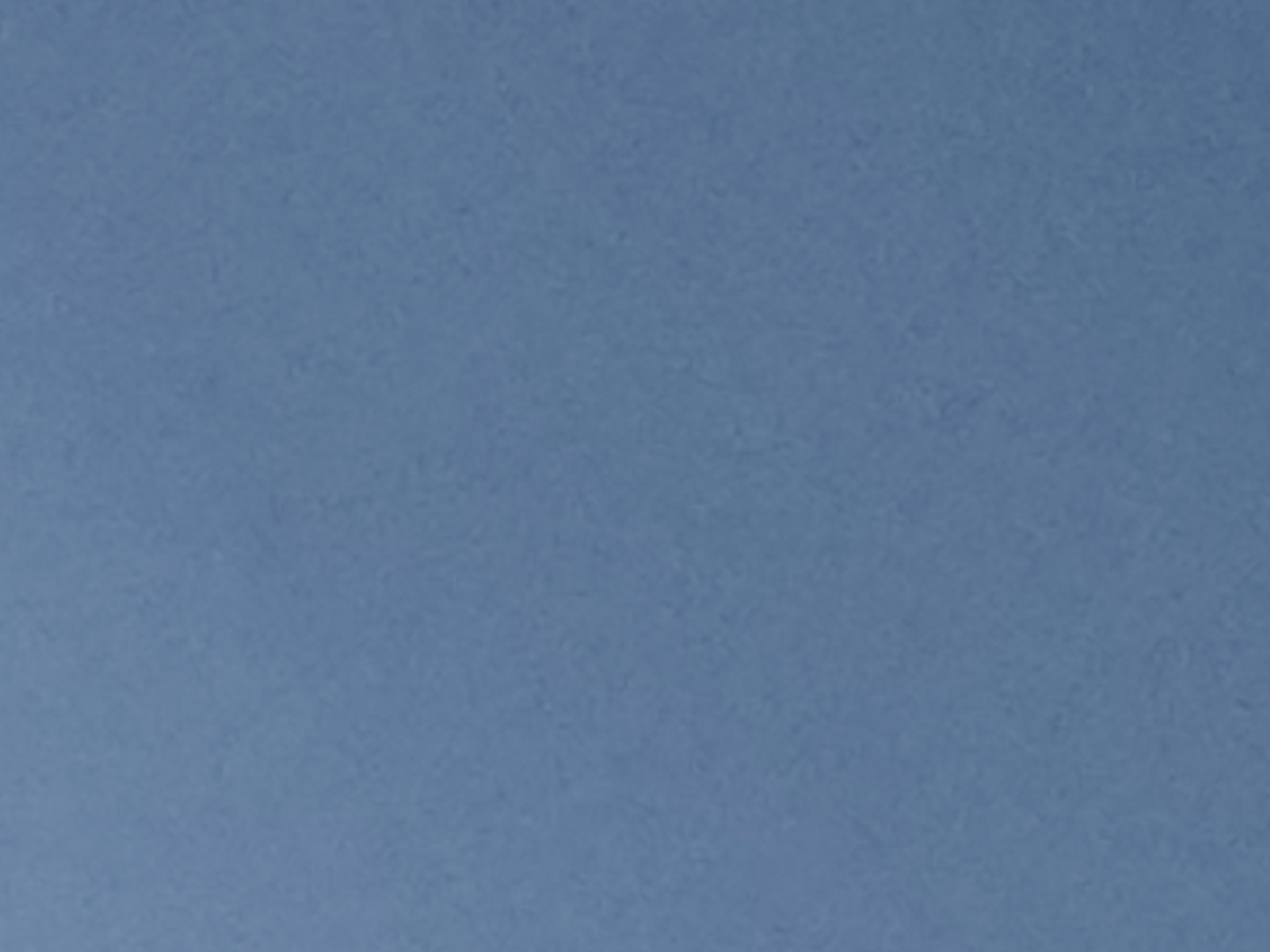 This media file is a cropped image showing a textured, solid blue surface. There are no discernible subjects, objects, activities, or events taking place. The image is abstract and lacks any specific details regarding time of day, weather, location cues, or emotions. No text is visible in the image.