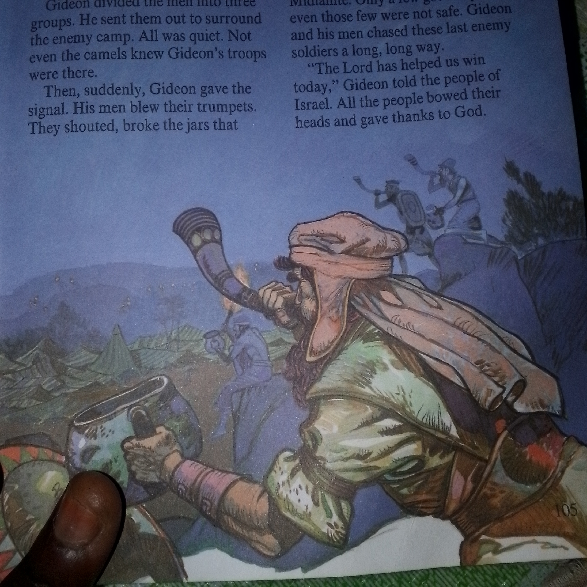 The image depicts a scene from a storybook, with text on the left and an illustration on the right. The text describes Gideon dividing his men into three groups to surround an enemy camp and their subsequent actions. The illustration shows several figures in a nighttime setting. A prominent figure in the foreground, wearing a red head covering and holding a horn, is blowing it. Other figures in the middle ground appear to be interacting with pottery and horns, likely reenacting the events described in the text. The background features a dimly lit landscape with hills, tents, and scattered lights, suggesting a military camp or battlefield. The overall atmosphere is one of action and impending conflict. The location is described as "Unknown, Unknown" within the context of the image.