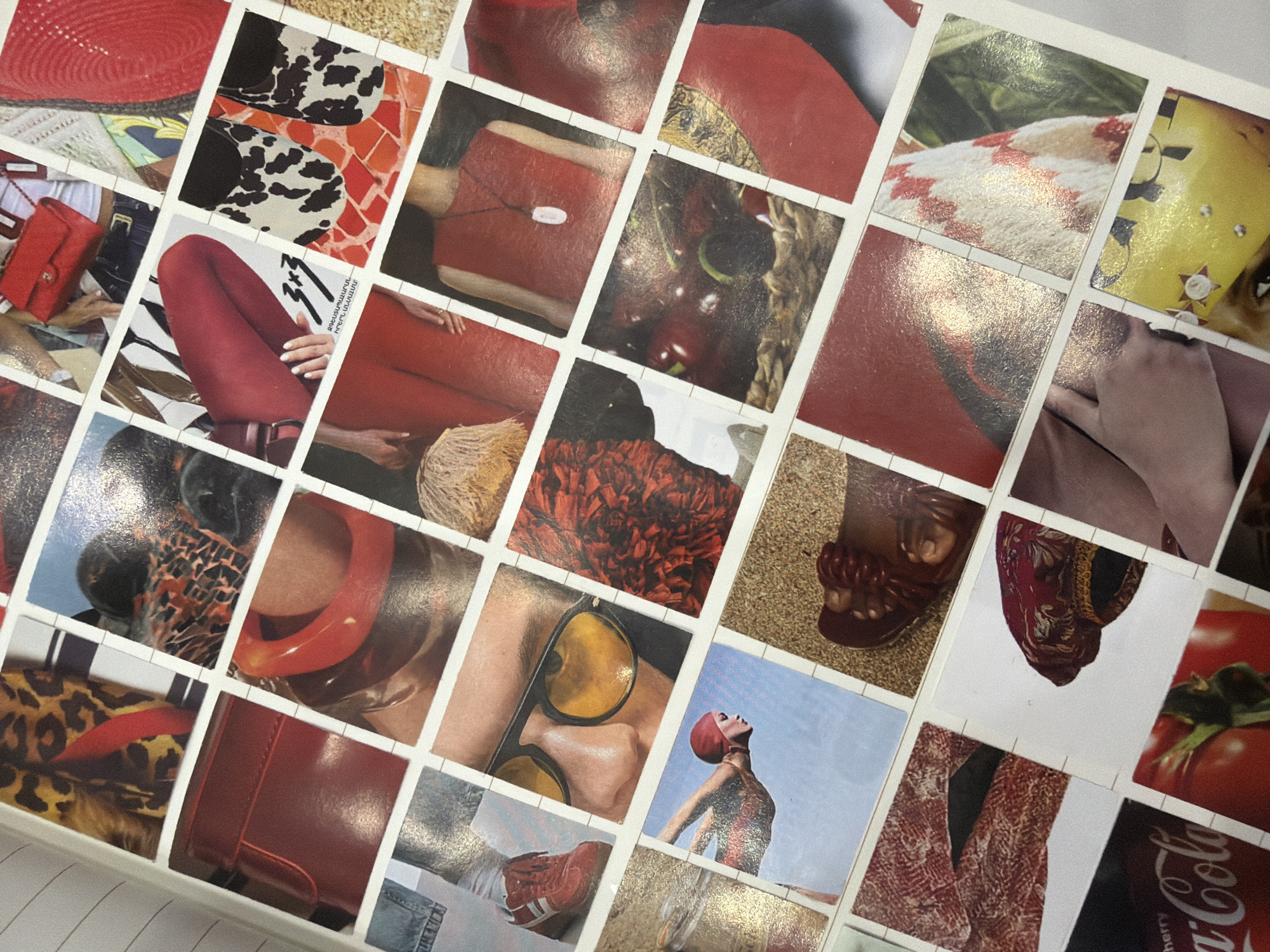The image shows a collage of small, square photographs arranged in a grid pattern, possibly glued onto a white surface like a box lid. The photographs seem to focus on the color red, featuring various objects and subjects predominantly in that color. Examples include: red hats, purses, boots, fabric, clothing (including a person wearing red tights), cherries, and even a Coca-Cola can. One image features a woman in a red bathing suit and cap, seen from a low angle against a clear sky. Another shows a person's face with yellow-tinted sunglasses. Some images show textures or patterns like cow print and animal print. There are no discernible indicators of Yerevan, Armenia, or any other specific location.