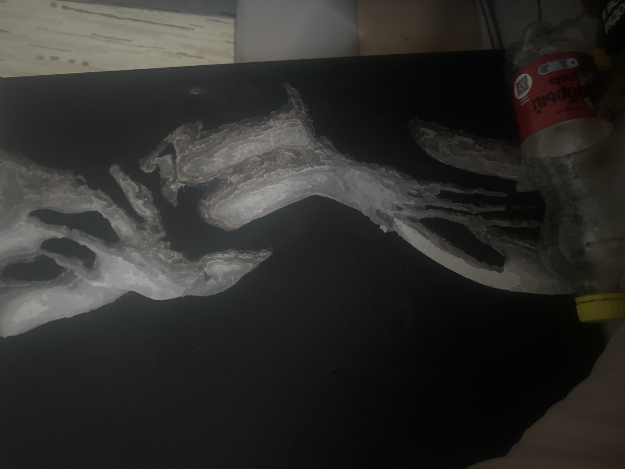 The image shows a dark surface with a painted or drawn map in grayscale. The map features detailed coastlines and landmasses. A plastic cola bottle with a red label is positioned on the right side of the surface, partially obscuring the map. The bottle appears to be mostly empty. The surface is located in Высокий, Russia. The map likely depicts Europe.