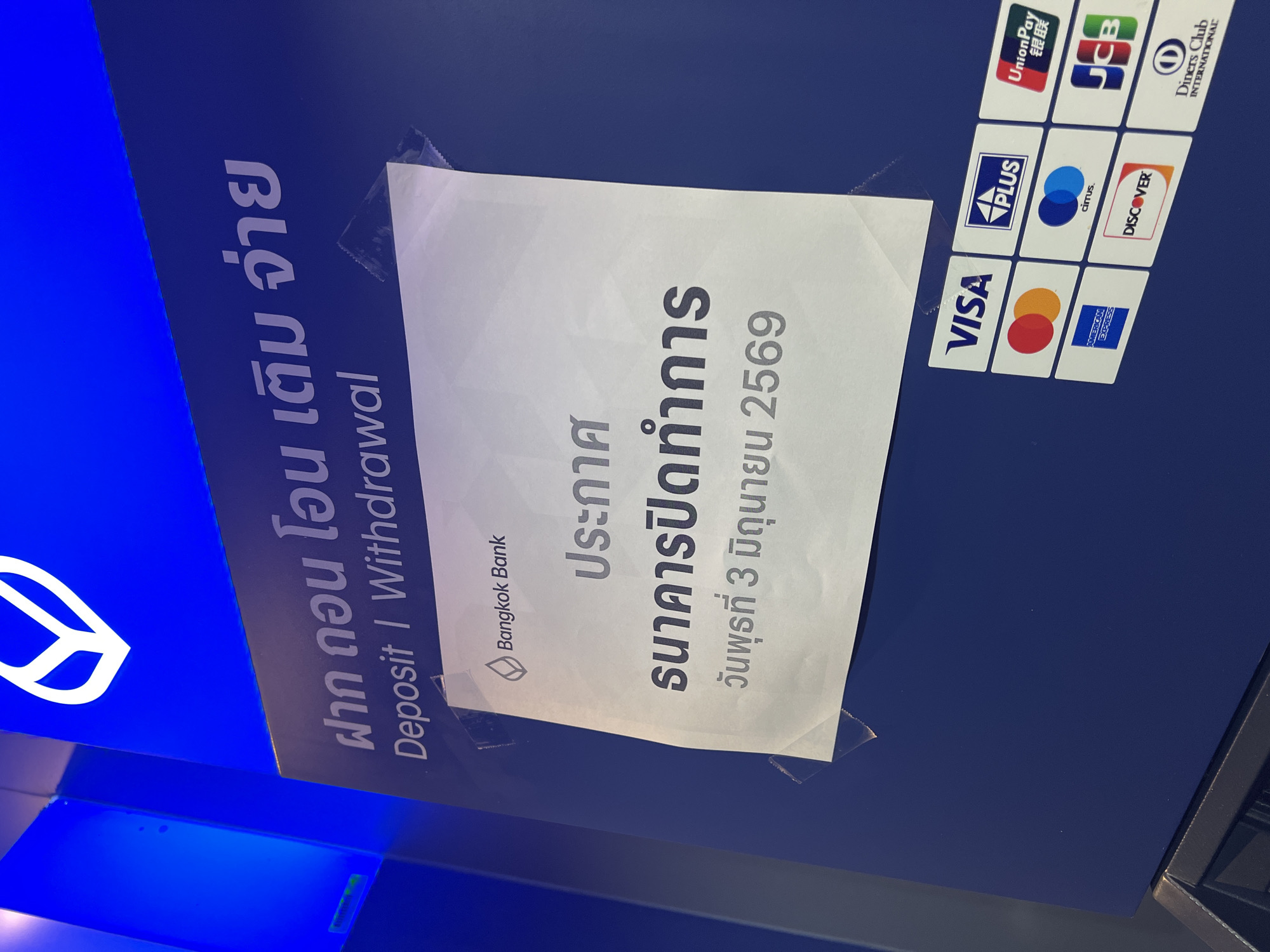The image shows a Bangkok Bank ATM in Baan Bo Phut, Thailand. The ATM accepts deposits and withdrawals and is marked with the Bangkok Bank logo and signage. It accepts various payment methods, including VISA, PLUS, UnionPay, JCB, Discover, American Express, and Diners Club International. A sign taped to the ATM indicates that the bank is closed on Wednesday, June 3, 2569 (Buddhist Era, equivalent to 2026 AD).