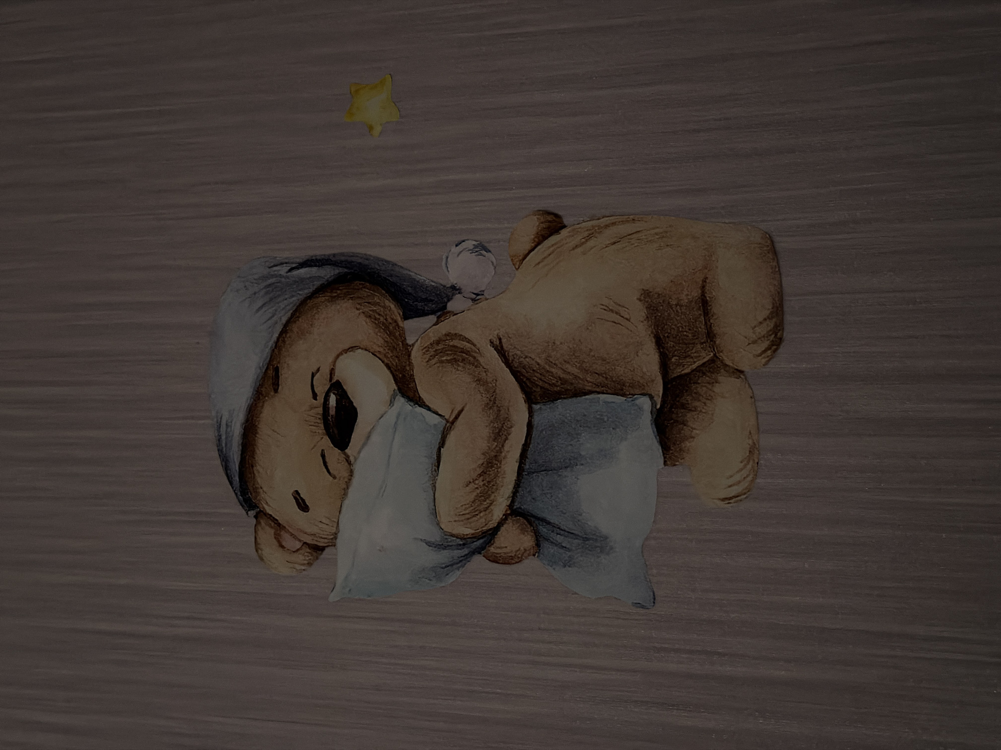 A watercolor illustration of a teddy bear wearing a blue sleep cap is depicted on a grey, textured background. The bear is hugging a light blue pillow and appears to be sleeping or resting. A small, yellow star is visible in the upper right corner of the image. The background has a subtle, vertical wood grain pattern. There are no people or interactions visible in the image, and the scene is static. The image does not provide any specific information about the city of Tenishevo, Russia, or its location.