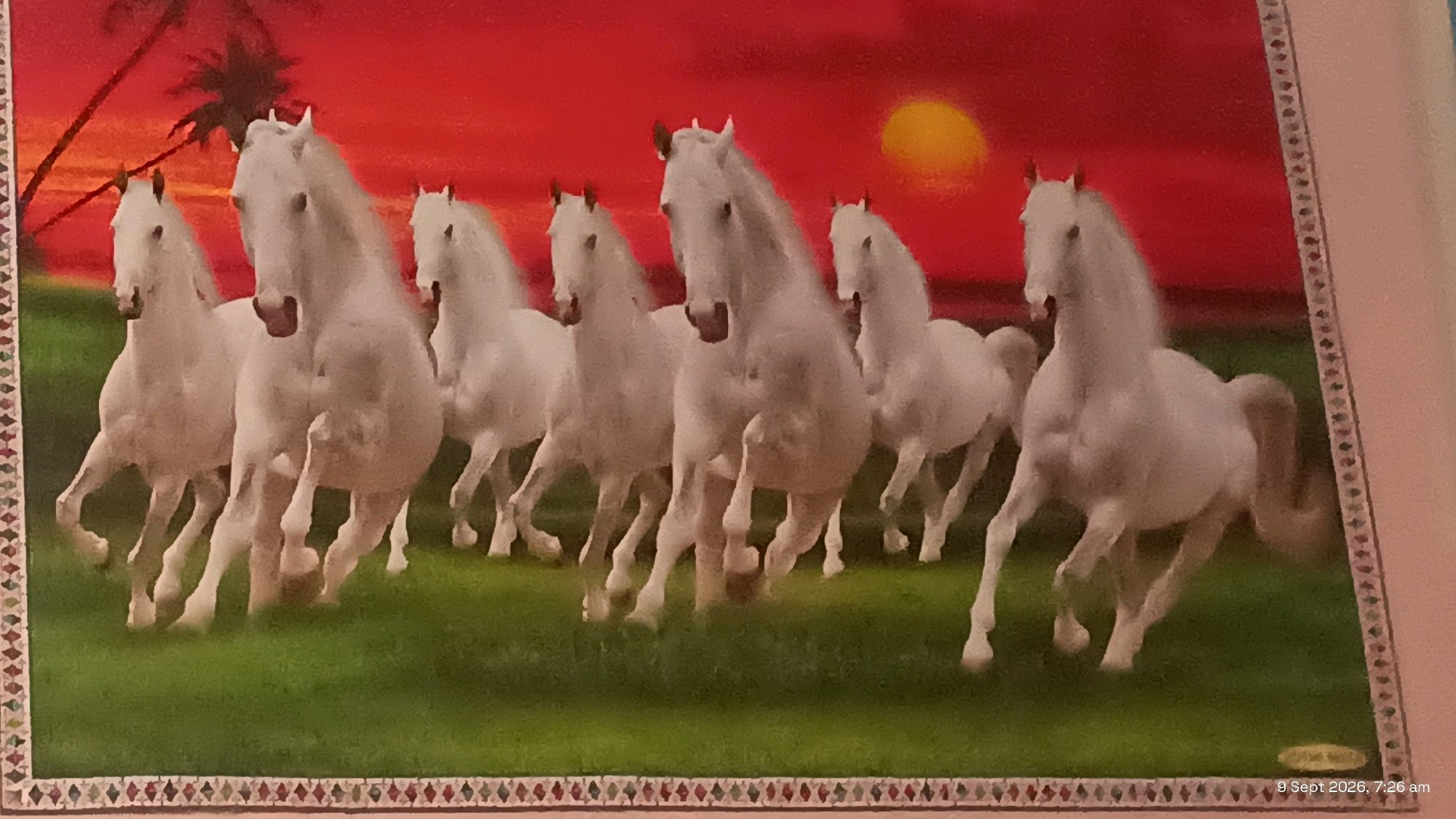 The image shows a digital painting of seven white horses running in a field of green grass with a red sunset in the background. There are palm trees on the left side of the image. The horses are in motion, with their legs extended and manes flowing. The painting has a decorative border at the bottom. A watermark with the text "9 Sept 2026, 7:26 am" is present in the bottom right corner. The image does not depict any recognizable location in the city of Udaipur, India.