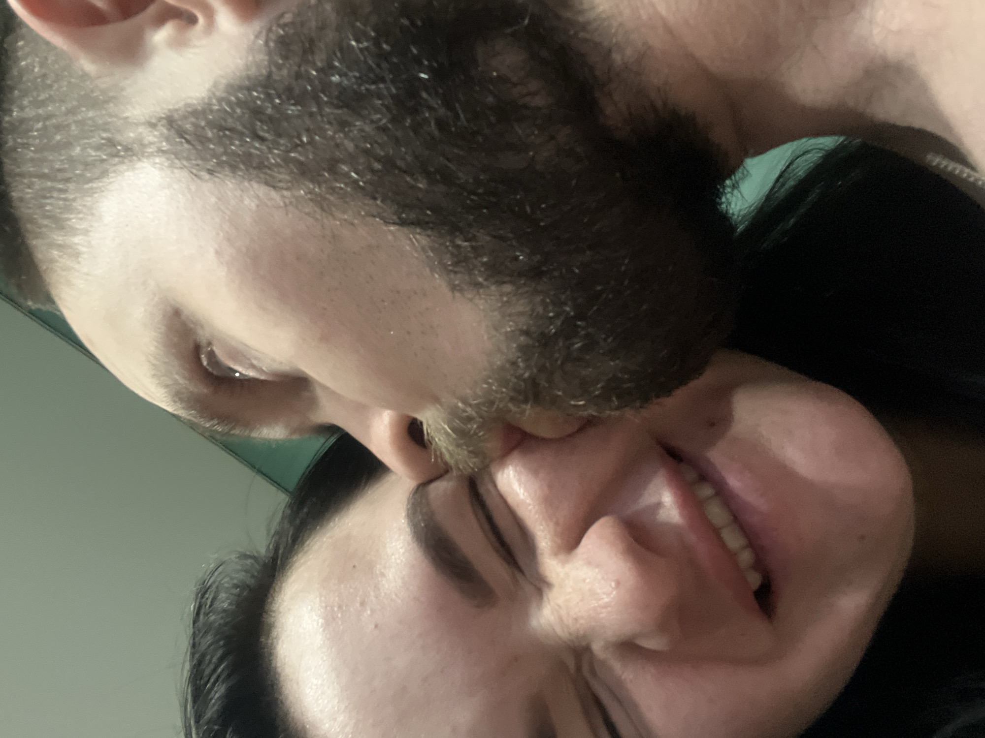 A man with a beard is kissing a woman on the forehead. The woman is smiling. The location is unknown, as there are no specific identifying factors such as landmarks or signage that could be used to identify the city of Kazan, Russia or any other location.