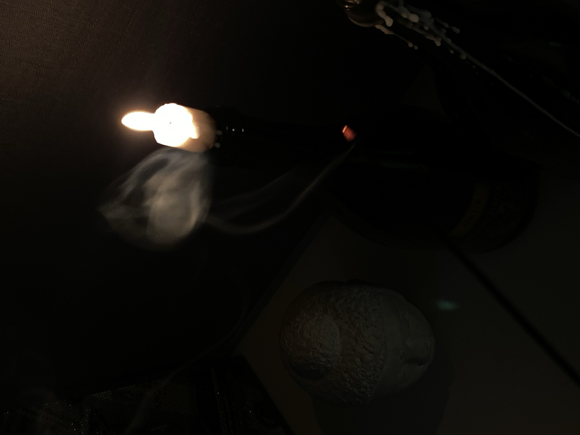 The image, taken in an unidentified location, presents a dimly lit scene. A champagne bottle is uncorked with considerable force, causing the cork to launch forward while simultaneously emitting smoke and foam. The surroundings consist of a dark, undefined environment.
There is no indication that the image was taken in Votkinsk, Russia.