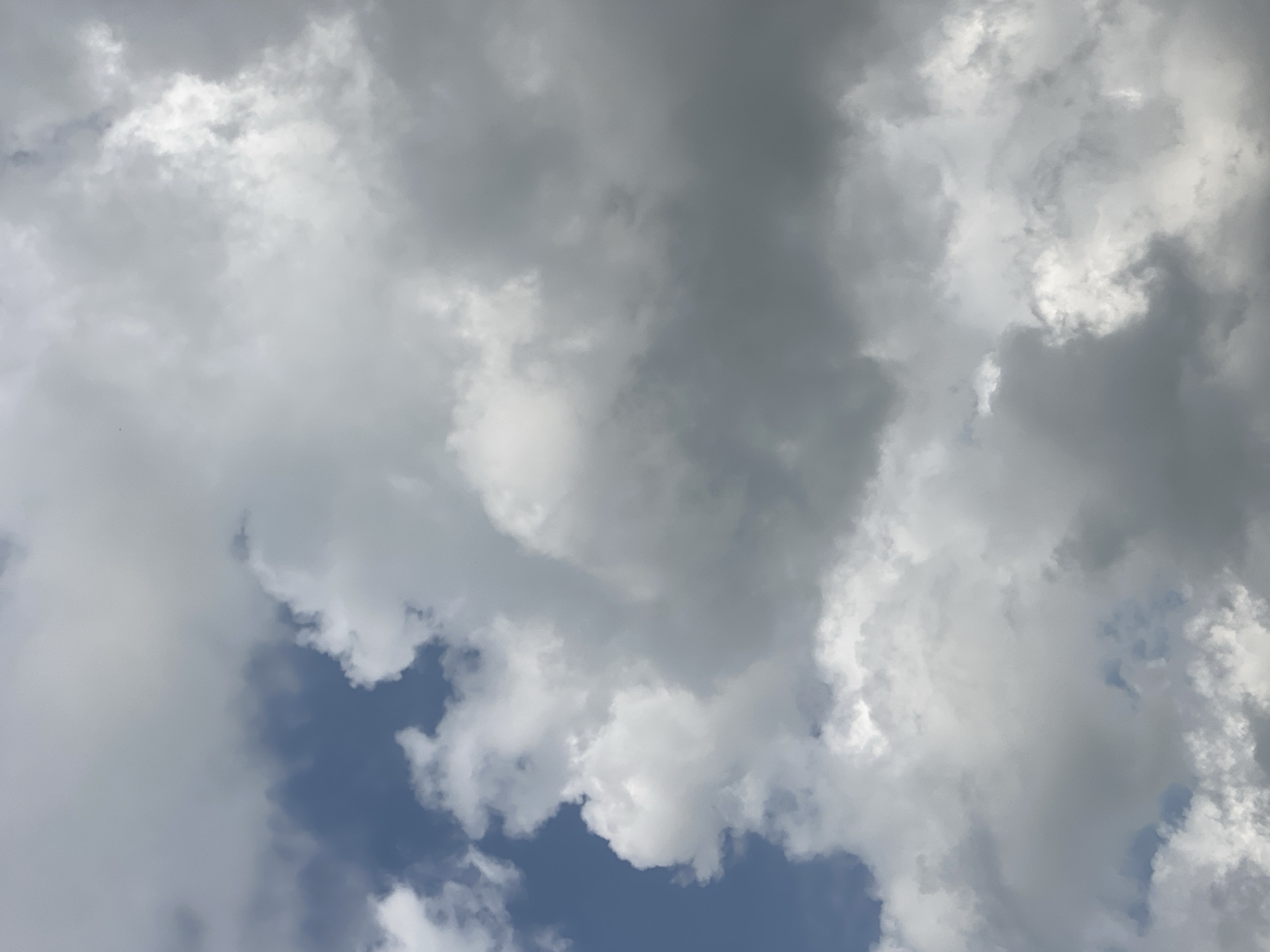 This is a photograph of a cloudy sky with patches of blue visible. The clouds are a mix of white and gray, with some appearing dense and others more wispy. The lighting suggests it is daytime. There are no people, subjects, objects, or actions depicted in this image, and it does not provide any information about the city of Maigizo, Nigeria. The scene is purely natural elements.