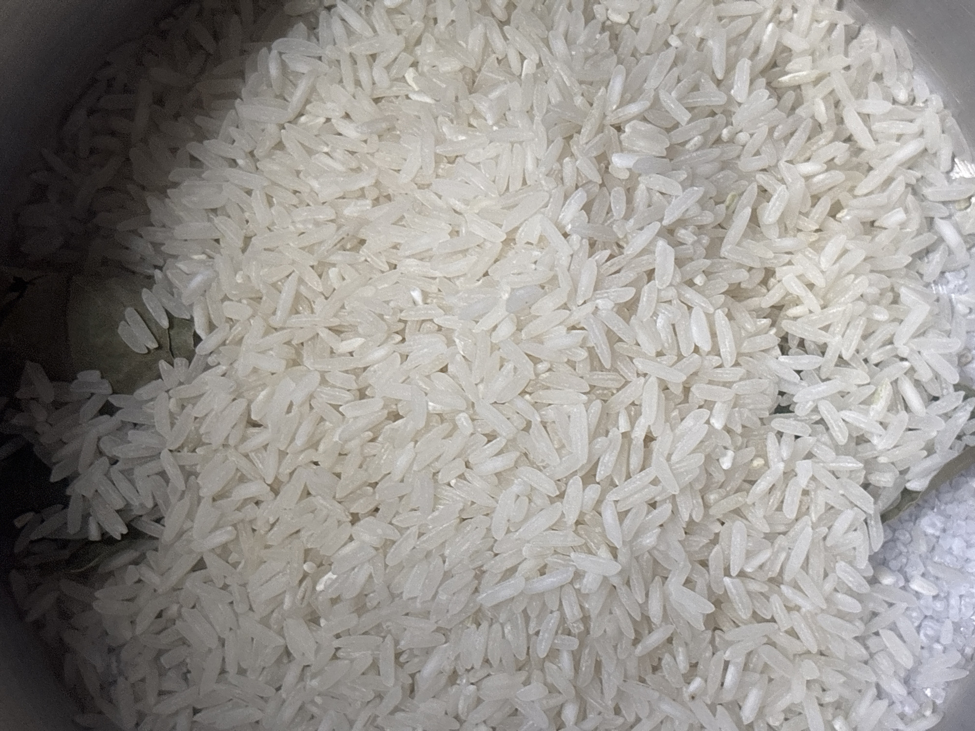 The image shows a close-up view of uncooked white rice, likely in a cooking pot. There's no visible information that indicates the location in Buenos Aires, Argentina, or any people, actions, or interactions. The environment consists solely of the rice grains.