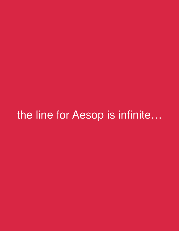 The image displays a solid, vibrant red background, devoid of any other visual elements like people, objects, or a discernable scene. White text is centrally positioned horizontally, located slightly below the vertical middle of the frame. The text reads: "the line for Aesop is infinite...". There are no other notable details such as time of day, weather, or specific location cues visible within the image itself. The overall impression is minimalist, focusing solely on the textual message against a stark, monochromatic backdrop.
