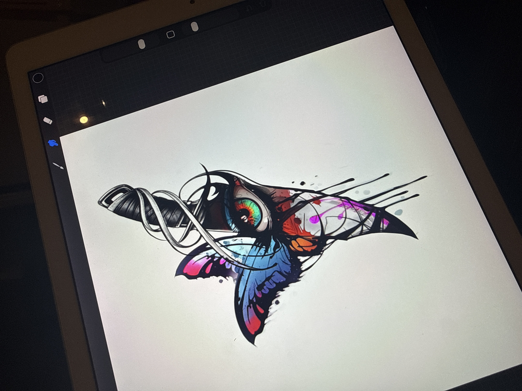 The image shows a digital tablet displaying a detailed, colorful digital artwork. The artwork features a central eye with a vibrant, multicolored iris, surrounded by black lines and shapes resembling a stylized butterfly or insect-like form. The design incorporates a mix of solid colors and ink-splatter effects. The tablet's screen is bright white, contrasting with the black borders and UI elements visible at the top and left of the screen. There is no discernable location in the city of Sofia, Bulgaria.