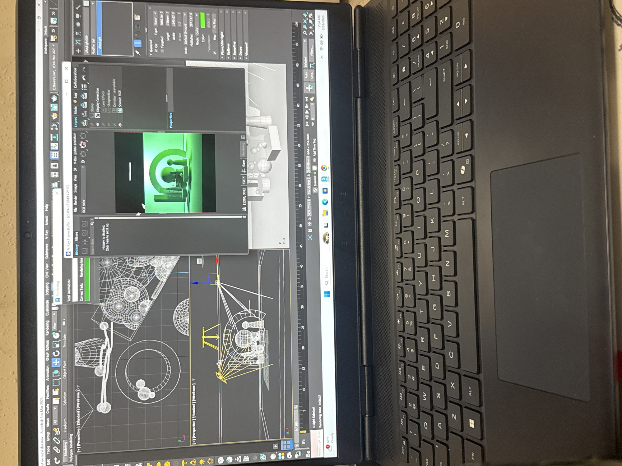 The image depicts a laptop screen displaying the Autodesk 3ds Max 2023 software. The software interface shows a 3D modeling scene with objects, wireframes, and rendering tools. A V-Ray frame buffer window is open, displaying rendering settings and controls.
The laptop keyboard is visible, indicating a typical laptop setup. There is a notification on the bottom right of the screen showing a weather forecast of 60°F and Cloudy, along with the date and time of 7:14 AM on May 18, 2026.
The location of Yerevan, Armenia, is not directly inferable from the image content, and no people or interactions are visible. The image solely depicts the software interface and laptop itself.