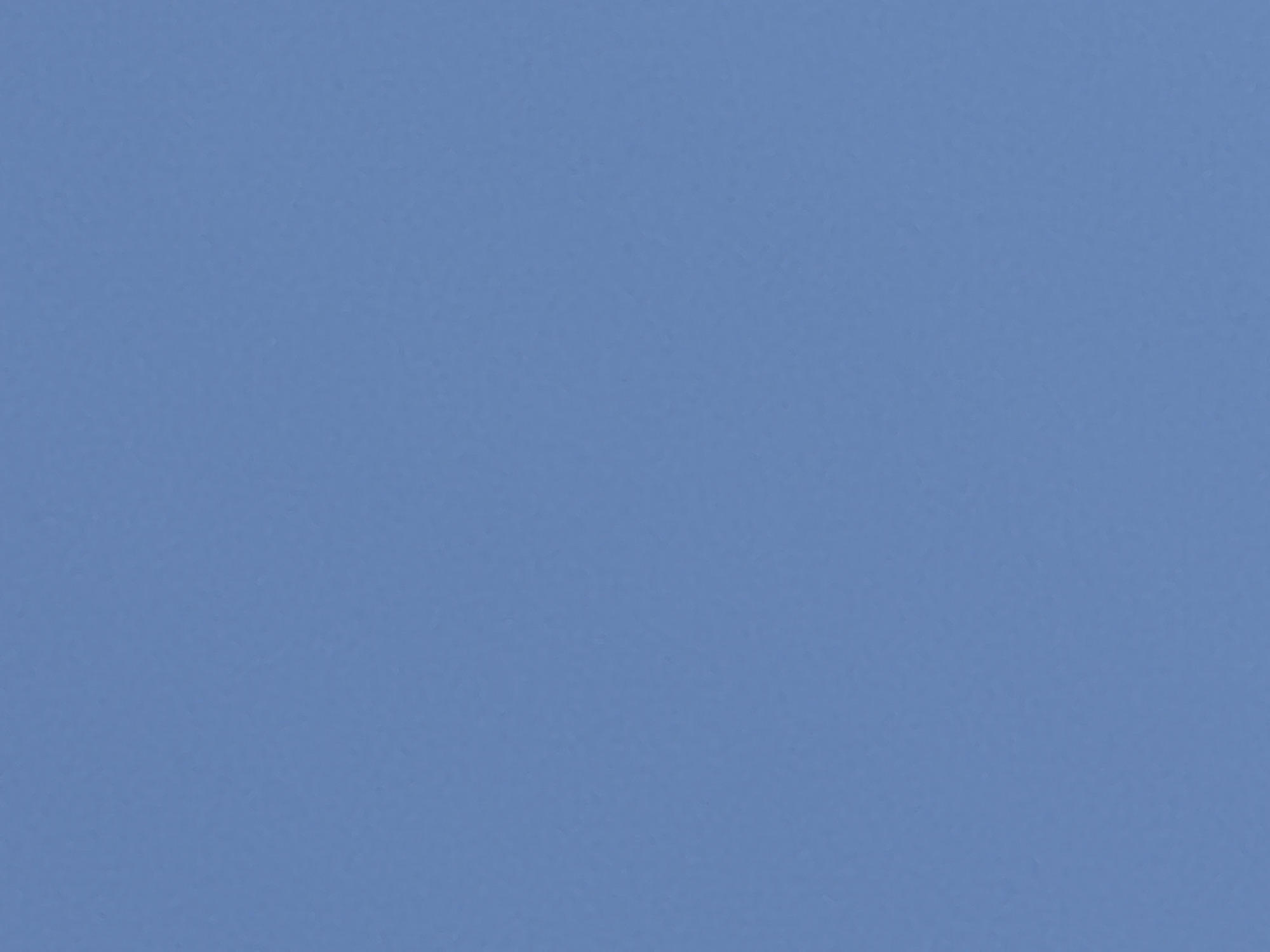 A plain blue sky fills the entire frame of the image. There are no discernable objects, people, or environmental features present. The texture of the sky appears slightly grainy, suggesting a photograph of the atmosphere.