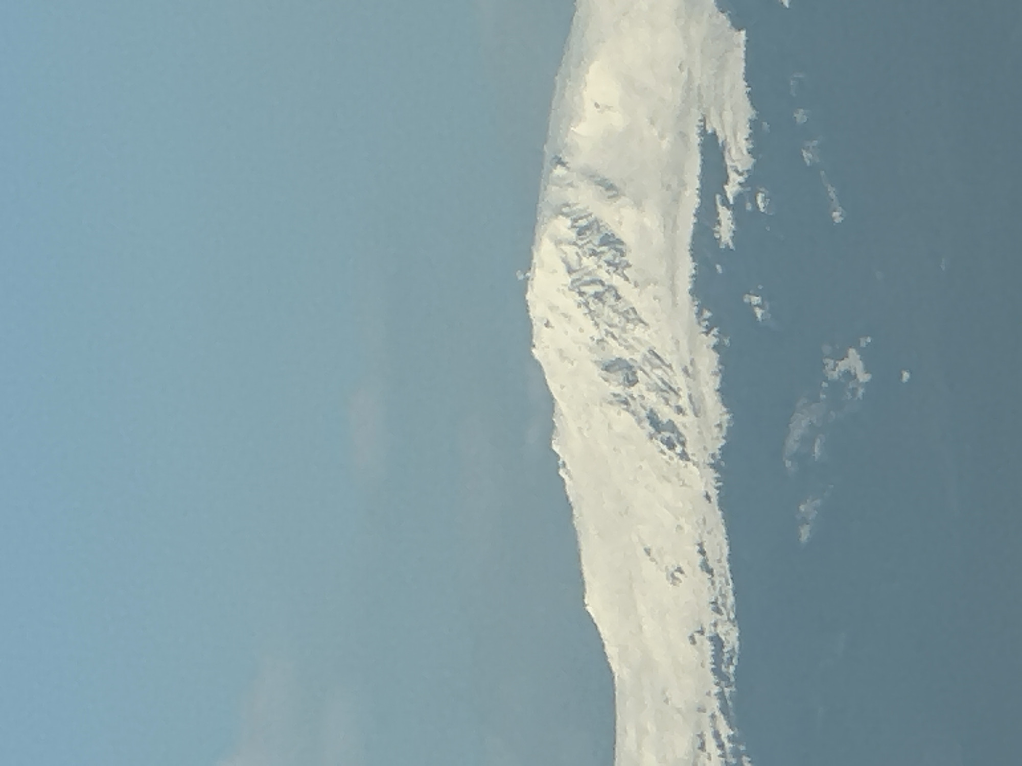 The image shows a snow-covered mountain against a blue sky. It does not provide enough information to determine its location in Sofia, Bulgaria, or include any people, objects, actions, or interactions.