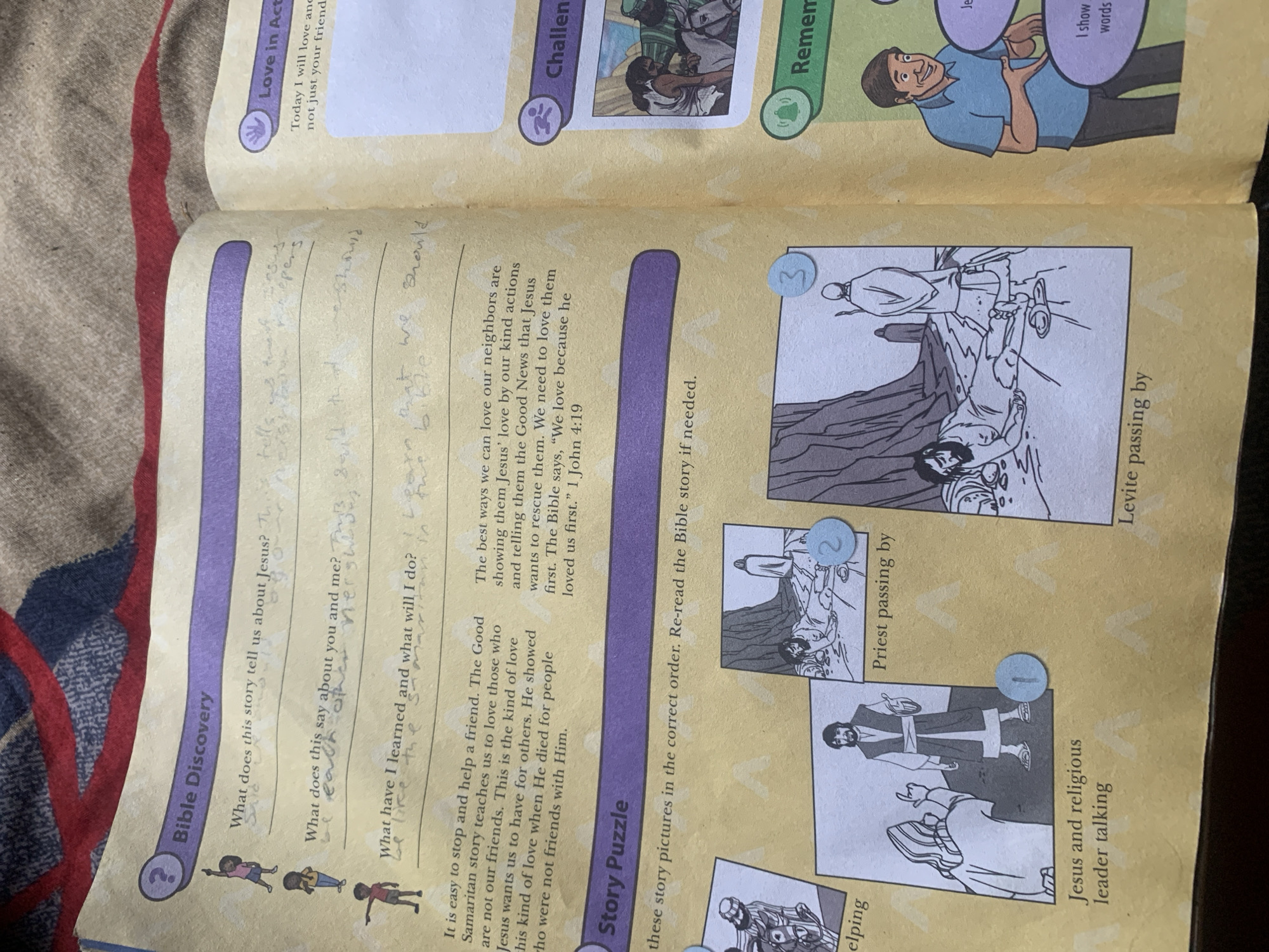 The image depicts an open book, likely a religious educational material. The left page features a section titled "Bible Discovery" with three questions and lined spaces for answers, all of which appear to be filled with handwritten text. Below this is a "Story Puzzle" section with a prompt to order pictures. Four illustrated panels are visible, depicting scenes from a Bible story. The panels are labeled with descriptions: "helping," "Priest passing by," "Jesus and religious leader talking," and "Levite passing by." The right page has sections titled "Love in Action," "Challeng," and "Remem" with illustrations and text.
There is no information within the image or its context to suggest a location in Jauro Yinu, Nigeria. The content is religious and educational in nature, related to biblical stories and lessons.