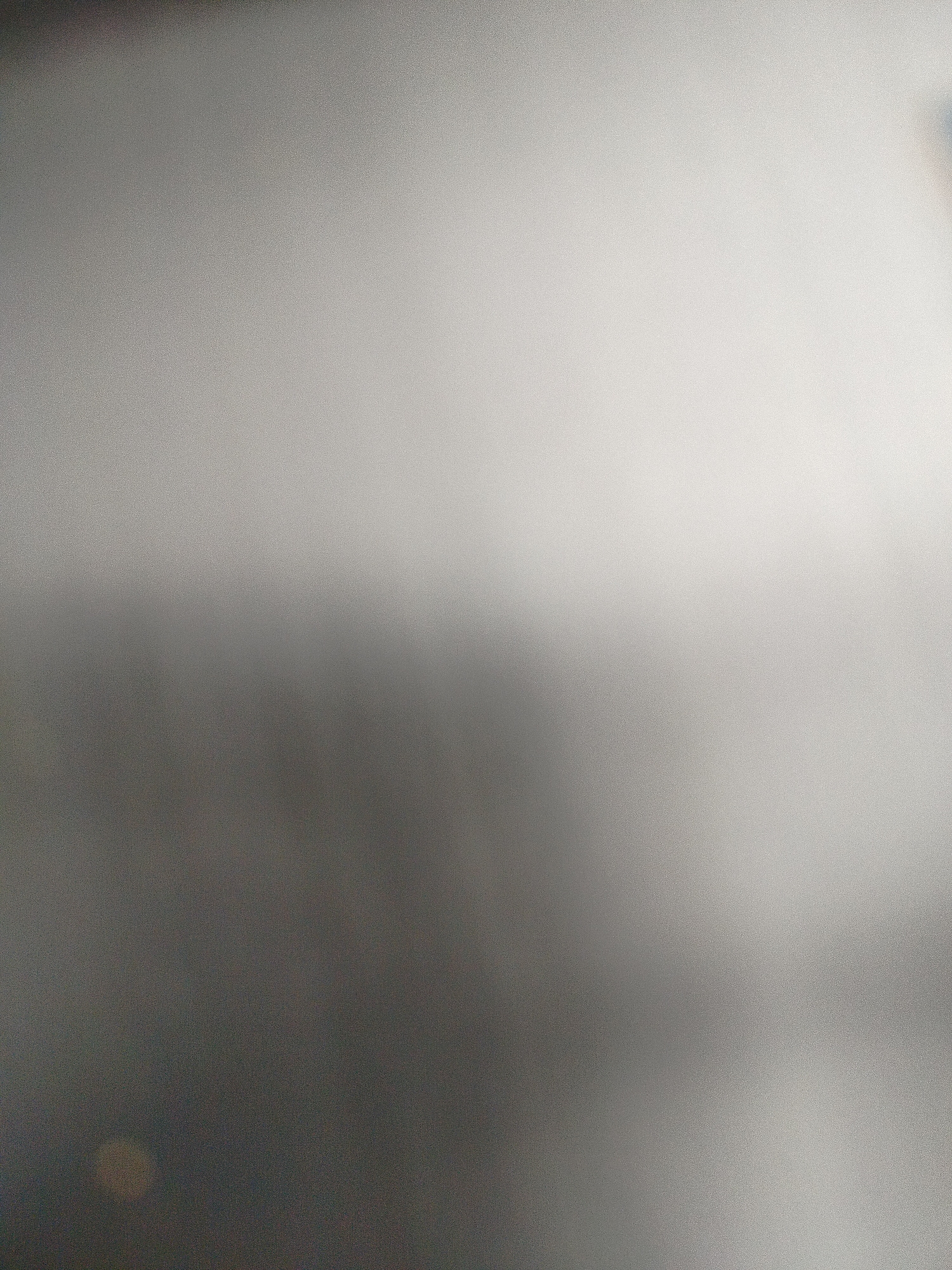 The image is an out-of-focus, gradient-toned gray field. It transitions from darker gray in the lower left corner to lighter gray/white in the upper right. There are no discernible objects, subjects, people, or activities visible. No definitive location in Yerevan, Armenia, can be determined from the content of the image.