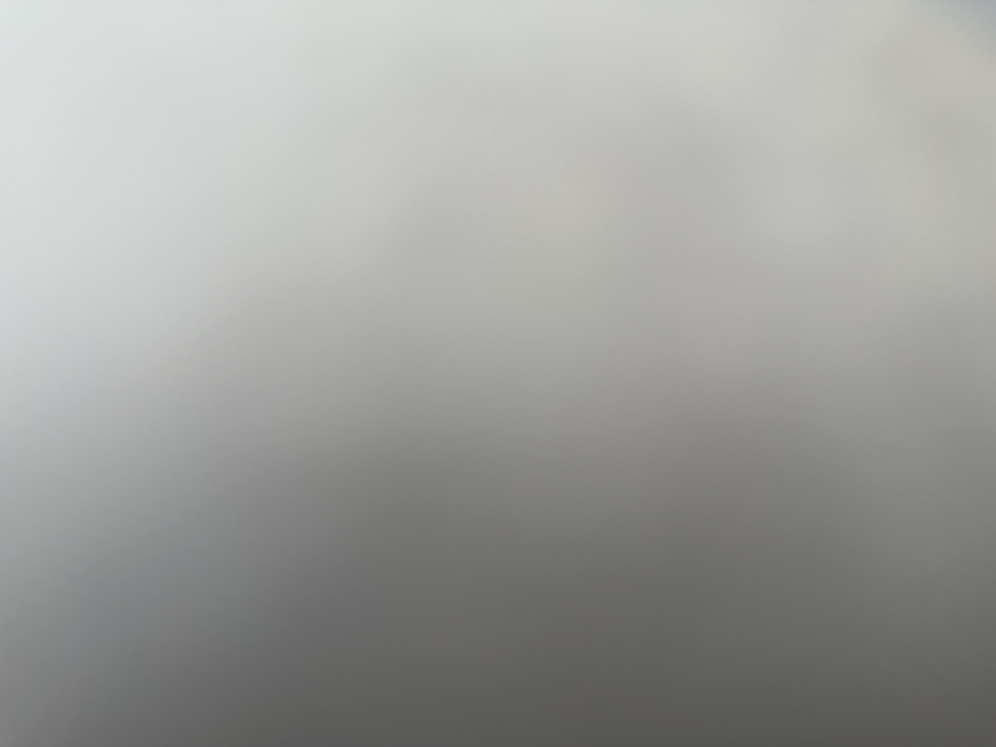 The image is an abstract, out-of-focus shot with a gradient of gray to white tones, suggesting a soft, diffused light source. There are no discernible objects, people, or environmental features to describe. The location in Belgrade, Serbia, cannot be determined from the visual information provided.