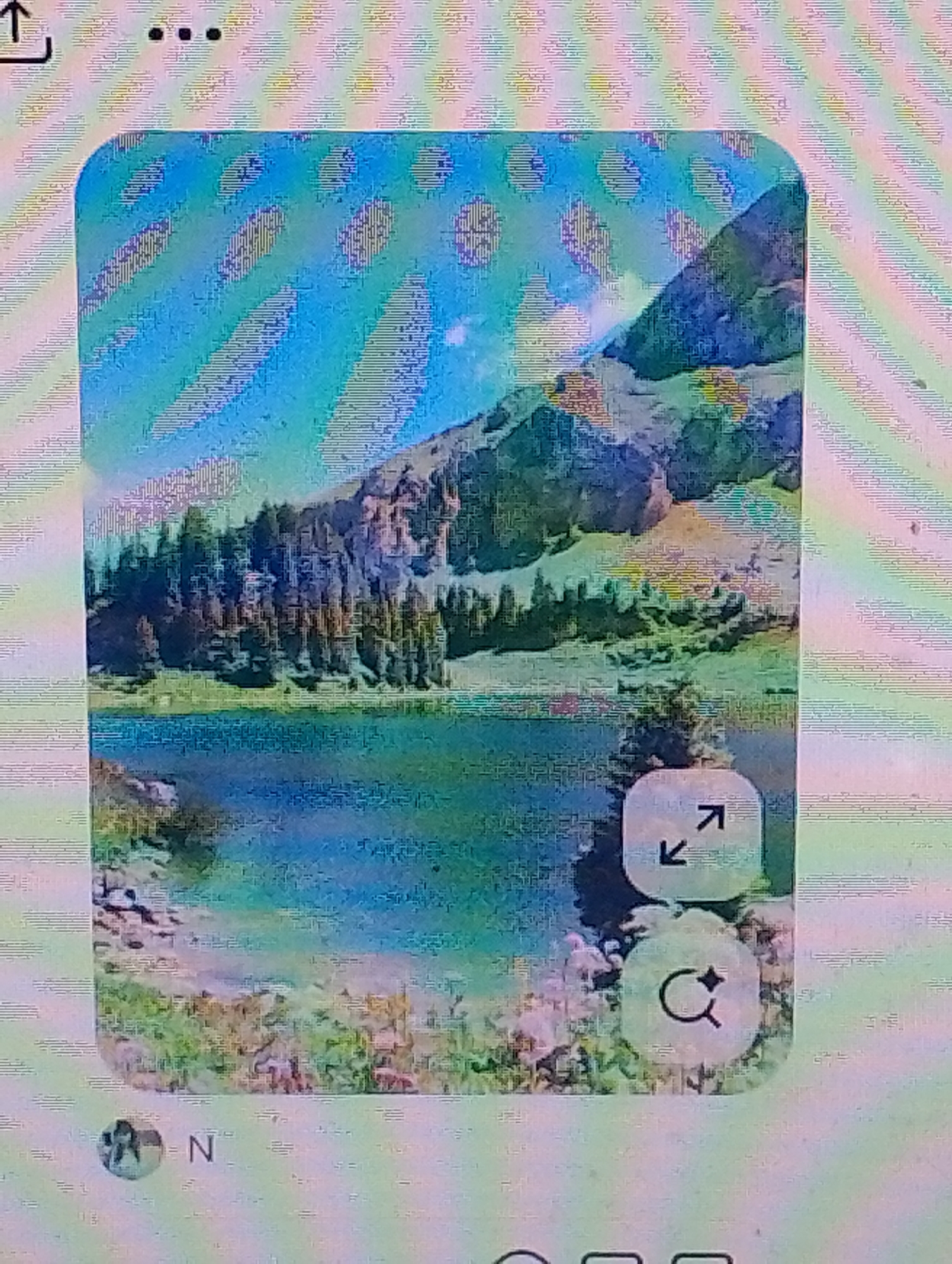 The image displays a scenic mountain landscape with a lake and evergreen trees. In the foreground, there is a body of water reflecting the sky and mountains. The background features rugged mountains with patches of green vegetation and snow. The sky is a vibrant blue with some scattered clouds. There are two circular icons overlaying the image: one with an expand and contract arrow, and another with a magnifying glass and a star. A profile picture and the initial "N" are visible at the bottom left of the image. The image quality is poor, with visible pixelation and banding artifacts.
The provided image does not contain any information or visual cues that would allow for its identification within the city of Magelang, Indonesia. Therefore, no description related to that specific location can be provided.