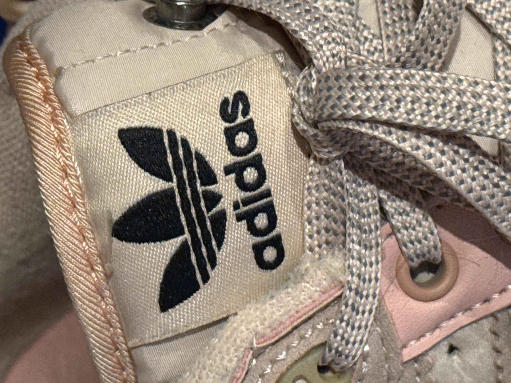 The image shows a close-up of an Adidas shoe. The Adidas logo is prominently displayed on a tag. The shoelaces are gray and knotted. Other details include the shoe's fabric, stitching, and metallic eyelet. The image does not include any information to suggest a location in Kladovitsy, Russia.