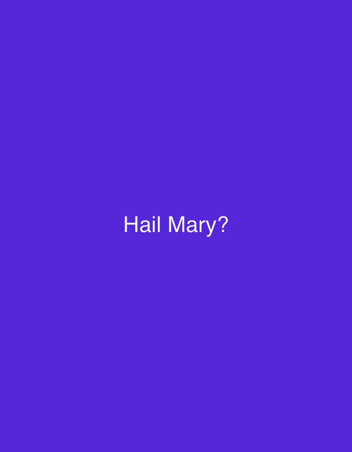 A medium-shot, indoor image showing the text "Hail Mary?" written in white against a solid purple background. There are no other objects, people, or discernible environmental details present. The location is not determined.