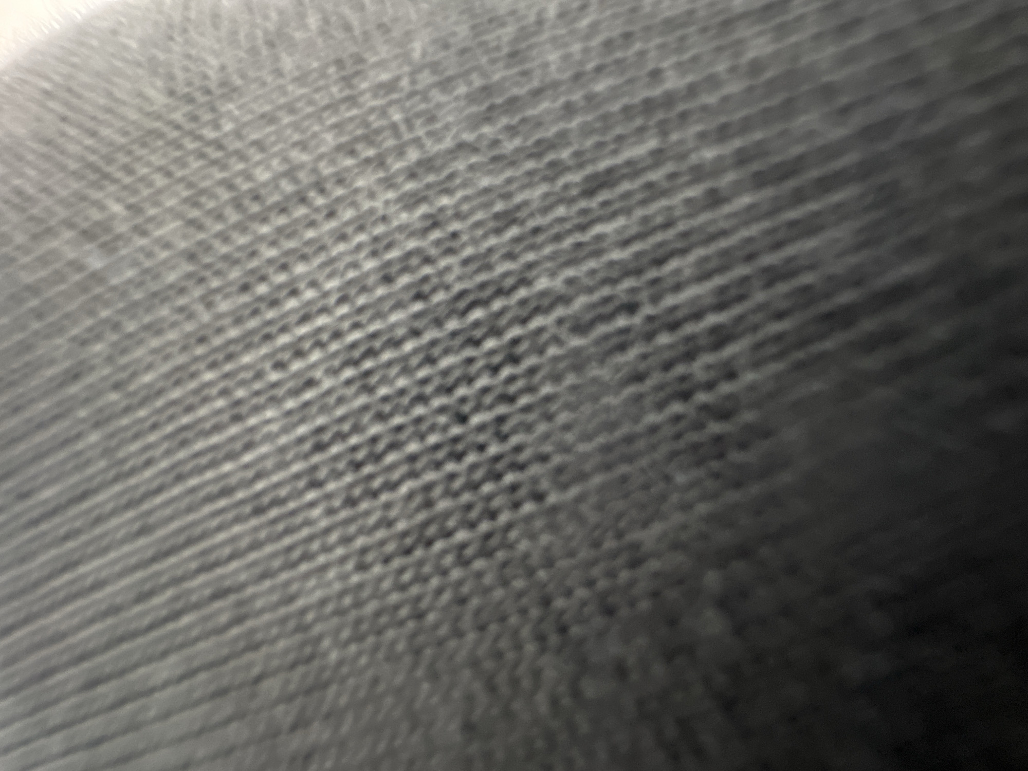 The image shows a close-up, blurred view of a textured fabric, likely gray or dark gray in color. The texture appears to be a woven or knitted pattern with diagonal lines. There are no discernible people, objects, or actions visible, and the image does not provide any information about a specific location in the city of Belgrade, Serbia. The focus is solely on the abstract texture of the material.