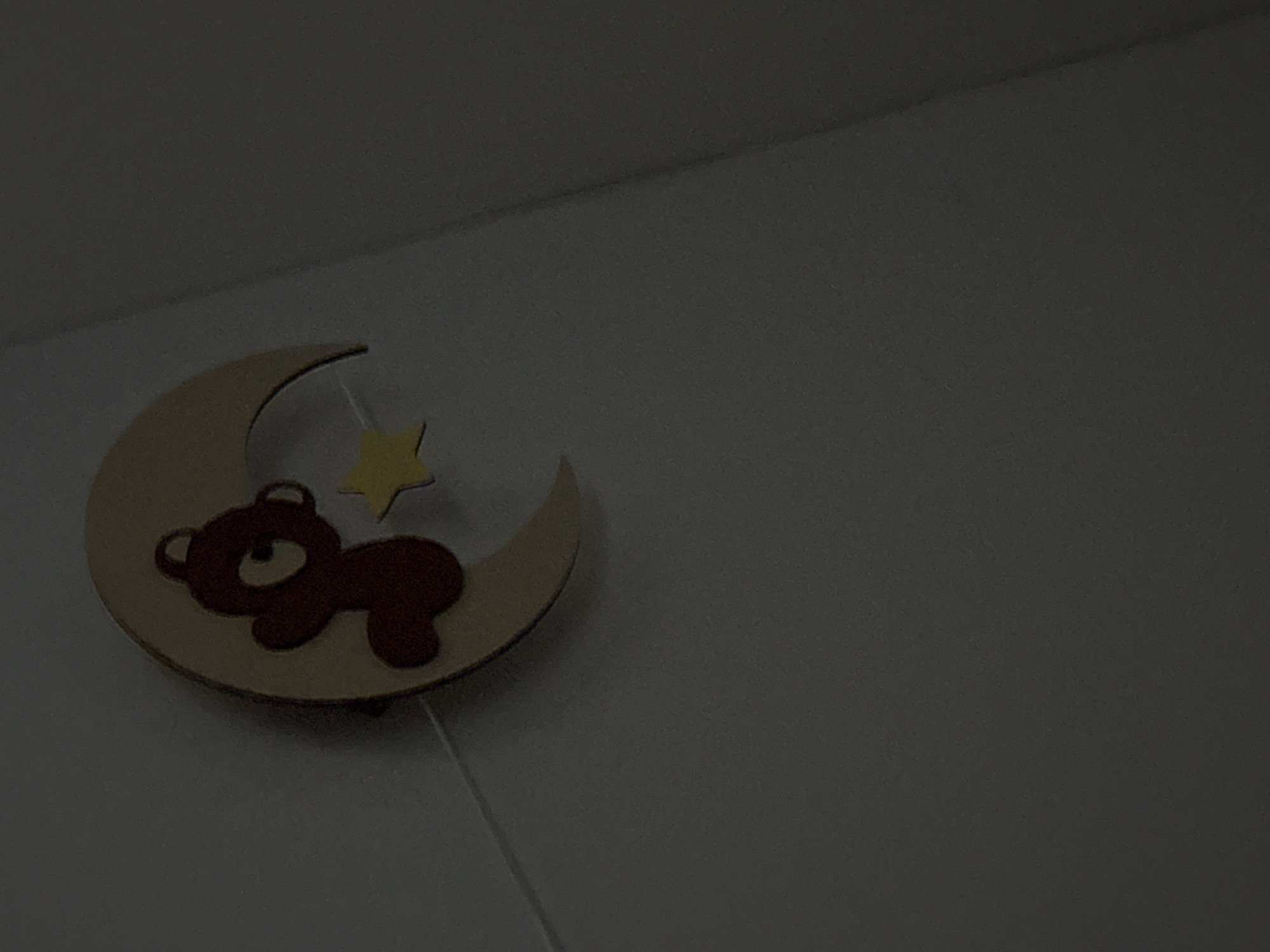 The image shows a child's room decoration featuring a crescent moon with a brown bear lying on it and a yellow star suspended above. The decoration is mounted on a light-colored wall. There is no indication of the location being Yakutsk, Russia, or any other specific city.