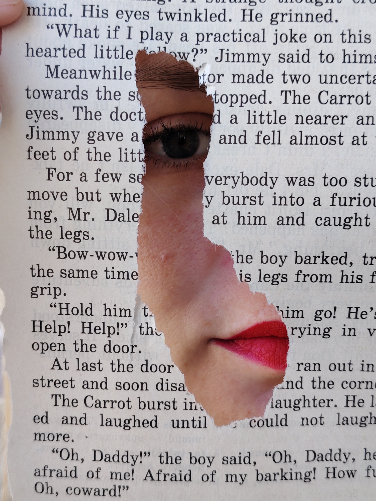 The image presents a close-up view of a page from a book, printed with black text on light paper. A large, irregular tear cuts through the page, revealing fragments of a human face. Through the upper part of the tear, a dark eye with prominent eyelashes and eyebrow is visible, looking directly forward. The surrounding skin is light-toned. Below this, the tear continues to reveal human lips, painted with bright red lipstick and slightly parted. The skin around the lips is also light. The visible text on the page includes phrases like "mind. His eyes twinkled. He grinned.", ""What if I play a practical joke on this", "Jimmy said to hims", "The Carrot", "For a few se", "Bow-wow-", "Help! Help!", "Oh, Daddy!" and "Afraid of my barking! How fu Oh, coward!". The torn page creates a surreal effect, suggesting a face emerging from or concealed within the narrative. The image focuses entirely on this juxtaposition of text and human features, with no other discernible objects, location cues, or time of day.