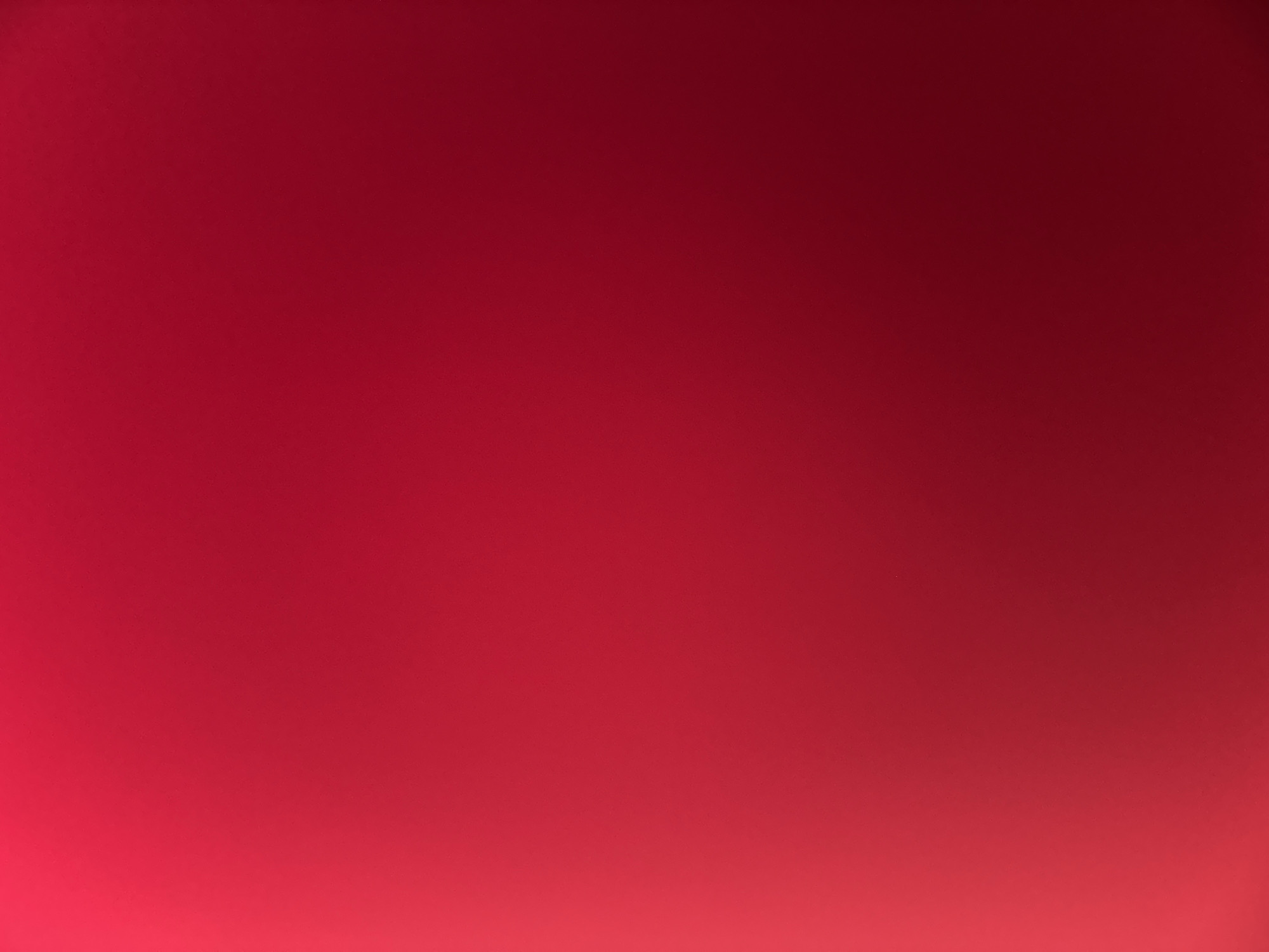 This is a close-up, abstract image of a red surface with a gradient of light. The lighting is brightest on the left side of the image and gradually fades to a darker shade of red towards the right. There are no discernible objects, people, or environmental features visible. The image is a uniform, textured red surface. It is impossible to determine its location in Belgrade, Serbia, as it lacks any identifiable context or landmarks.