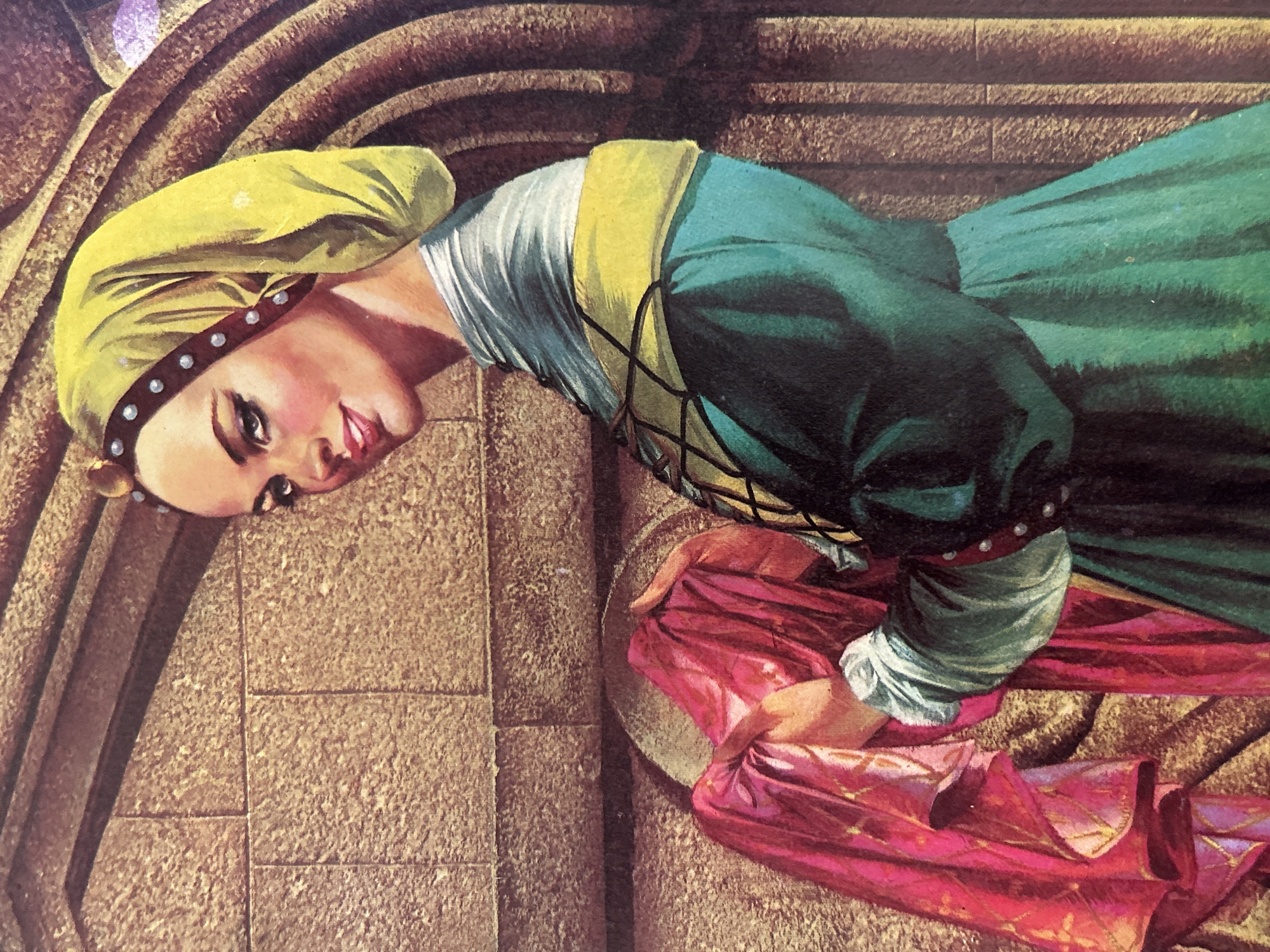 This is a close-up, detailed painting of a woman in historical attire. She is looking towards the viewer with a slight smile and dark, dramatic eye makeup. The woman wears a bright yellow headscarf adorned with a band of dark studs. Her clothing consists of a teal dress with a yellow sash and a white undershirt with puffed sleeves. She is holding a red fabric in her hands, which is draped over her left arm. The background appears to be a textured stone wall with arched architectural elements. There is no indication of Santa Ana, Venezuela in the image or any surrounding context.