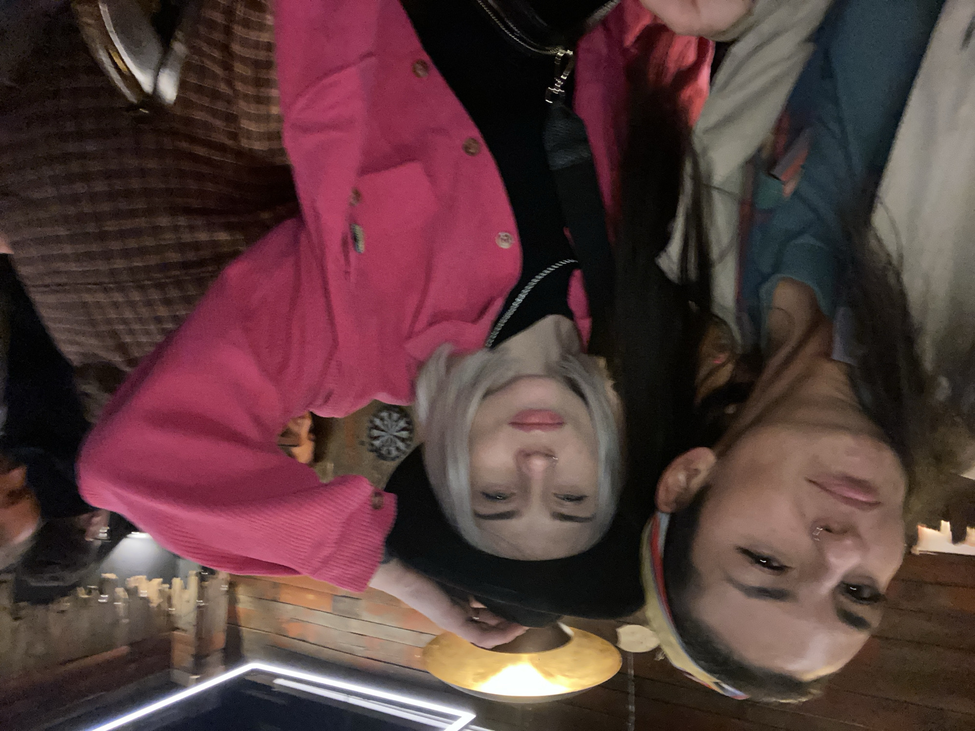 Two people are posing in the photo. The person on the left has blonde hair and is wearing a black hat and a pink jacket. The person on the right has dark hair and is wearing a colorful headband. It's difficult to pinpoint the location as Moscow, Russia with the information available.