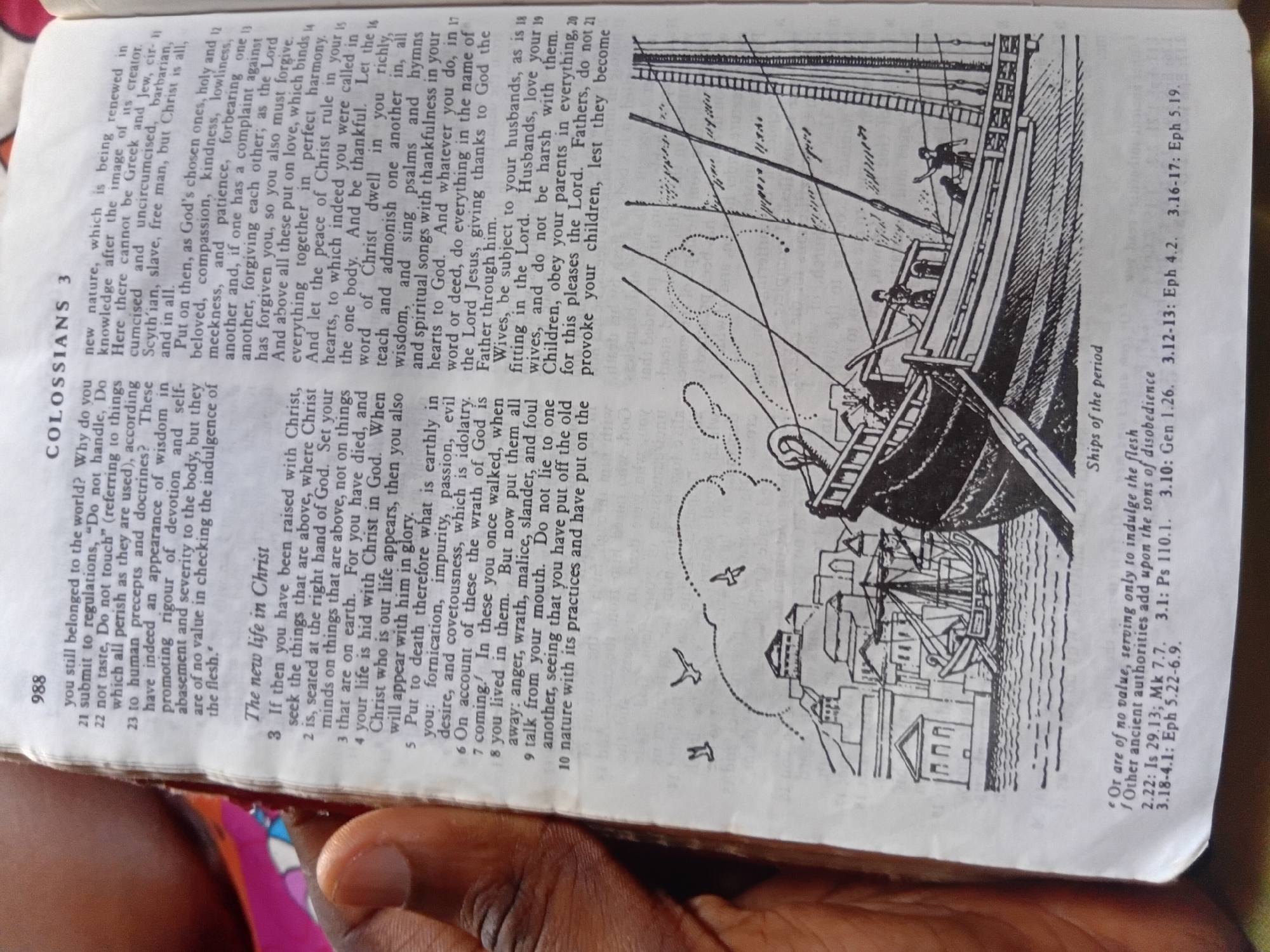 This media file shows an open Bible, with a drawing of a ship and a bustling harbor scene on the right-hand page. The text is from the book of Colossians, Chapter 3, with verses numbered. The drawing depicts several sailing ships, some docked at buildings, suggesting a historical port. There are small figures of people on the ship and in the background. The lighting appears to be natural, possibly from a window, illuminating the pages. The presence of a hand visible in the lower part of the image indicates a person is holding the Bible open. The text mentions "Ships of the period" as a caption for the drawing. The page number "988" is visible on the left. The context "Nkpor, Nigeria" suggests the photo was taken in that location.