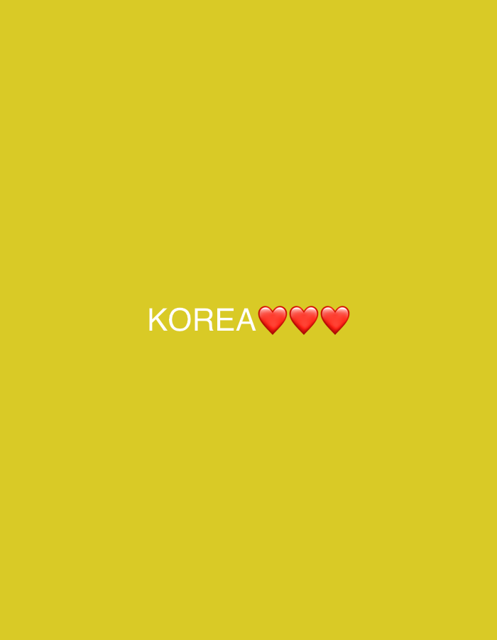 The image shows the word "KOREA" written in white text, followed by three red heart emojis. The background is a solid yellow color. The text and emojis are centered horizontally in the frame and positioned towards the bottom. There are no people, buildings, or any other objects present in the image. The image is a simple graphic with text and emojis on a plain background. No specific location in Gyeongju-si, South Korea is depicted.