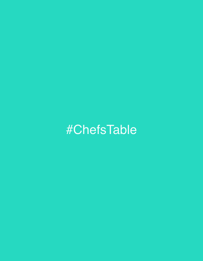 The image is a turquoise background with the white text "#ChefsTable" centered horizontally and vertically.