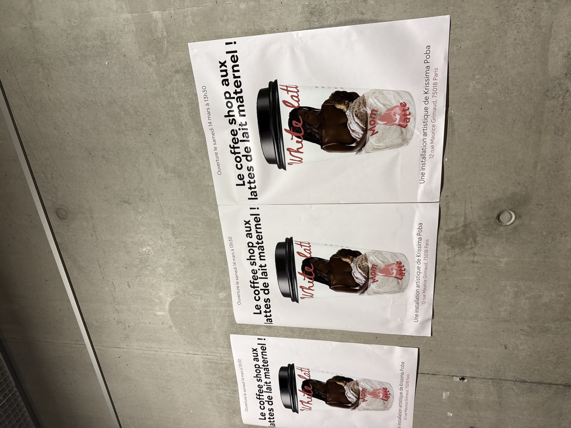 The image shows three posters displayed on a concrete wall. Each poster advertises "Le coffee shop aux lattes de lait maternel!" (The coffee shop with breast milk lattes). The posters feature an image of a coffee cup labeled "White latt" with an image of a mother and child. The posters state "Ouverture le samedi 14 mars à 13h30" (Opening Saturday, March 14 at 13:30). The bottom of each poster reads "Une installation artistique de Krissima Poba, 12 rue Maurice Grimaud, 75018 Paris" (An artistic installation by Krissima Poba, 12 rue Maurice Grimaud, 75018 Paris). This address places the location in the 18th arrondissement of Paris, France.