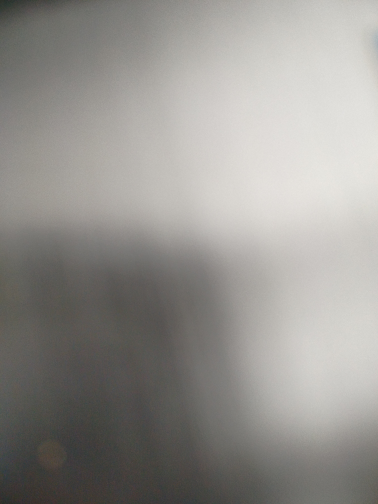 The image is a blurry, out-of-focus shot with a gradient ranging from dark grey/black at the bottom to a lighter grey/white at the top. There are no recognizable objects or people visible. Based on the image alone, determining a specific location in Yerevan, Armenia, is impossible.