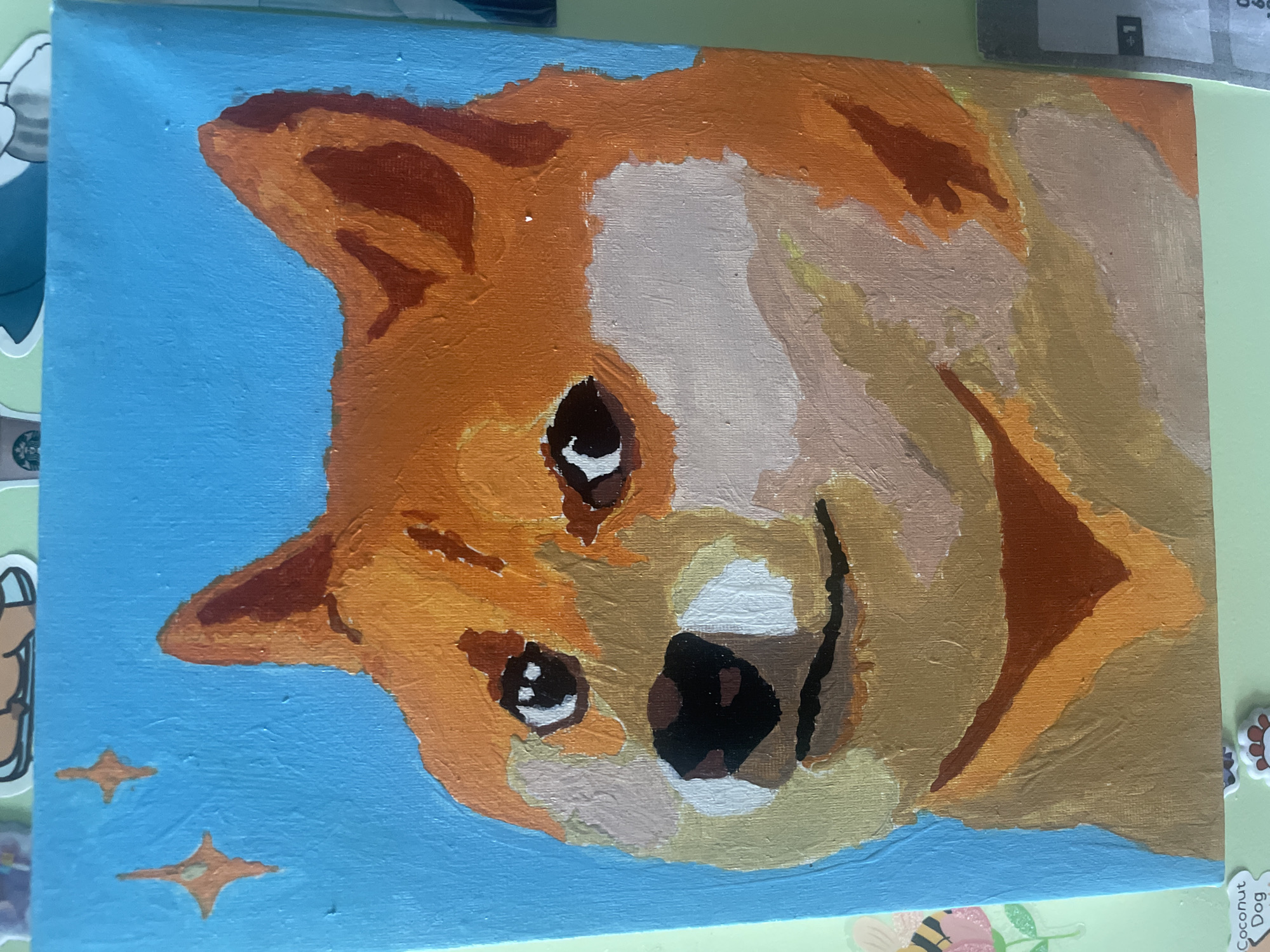 A painting of a Shiba Inu dog is depicted on a canvas. The dog's head is the primary subject. The background is light blue with two 4 pointed stars. The painting style is representational, with visible brushstrokes. The color palette is dominated by oranges, browns, black, white, and blues. The dog has a black nose, bright eyes, and pointed ears.
There is no location in Saratov, Russia discernible from the image.