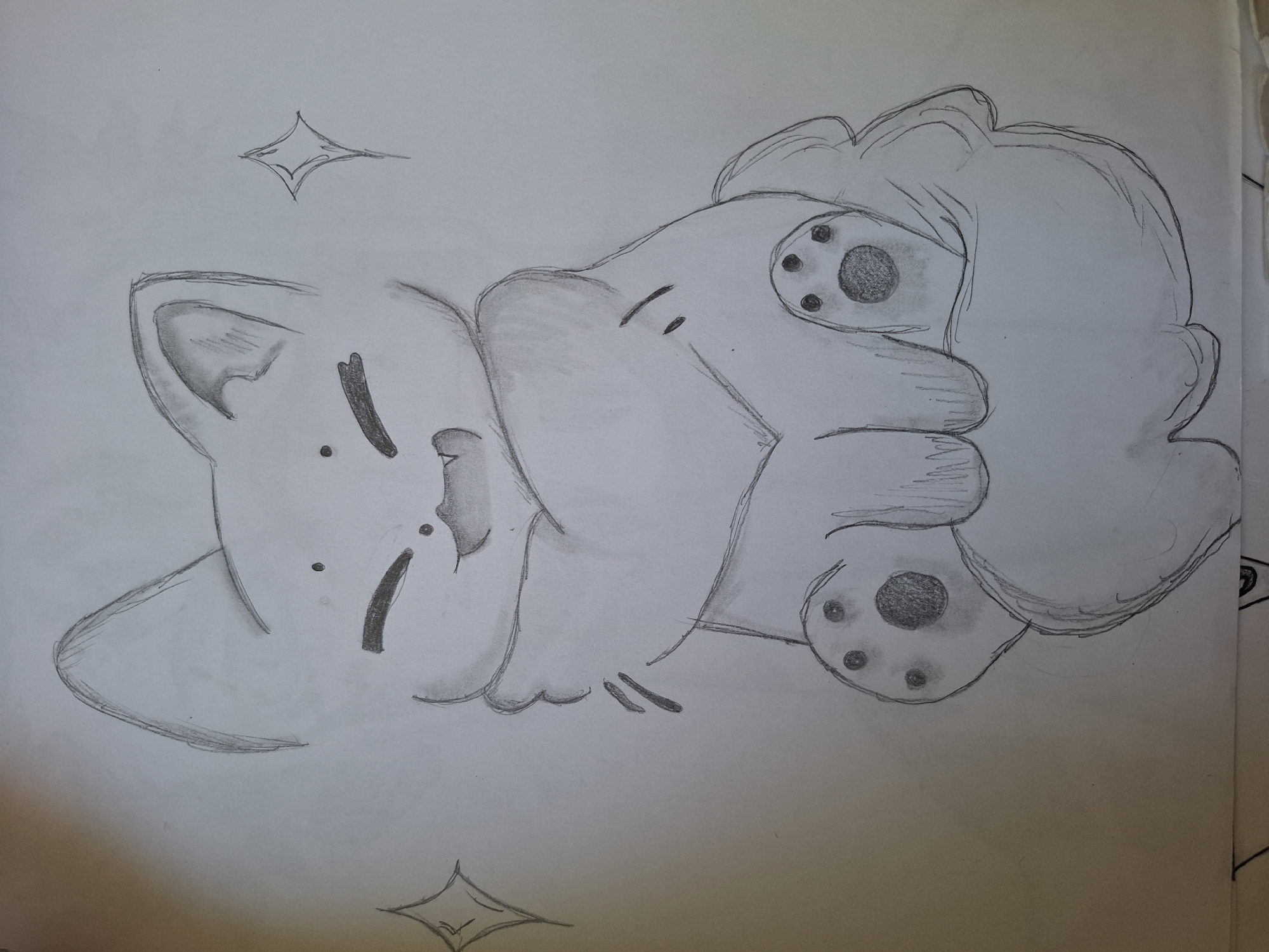 The image is a pencil sketch of a cartoon fox character. The fox is depicted sitting down with its legs tucked underneath it, resting on what appears to be a fluffy cloud or pillow. It has large, expressive eyes, a wide smile with visible teeth, and pointed ears. A scarf is wrapped around its neck. The sketch also includes two sparkling star shapes, one on each side of the fox's head. The drawing is on white paper and appears to be a hand-drawn illustration. There is no visible connection to the city of Varna, Bulgaria, nor any elements suggesting an urban or specific geographic location.