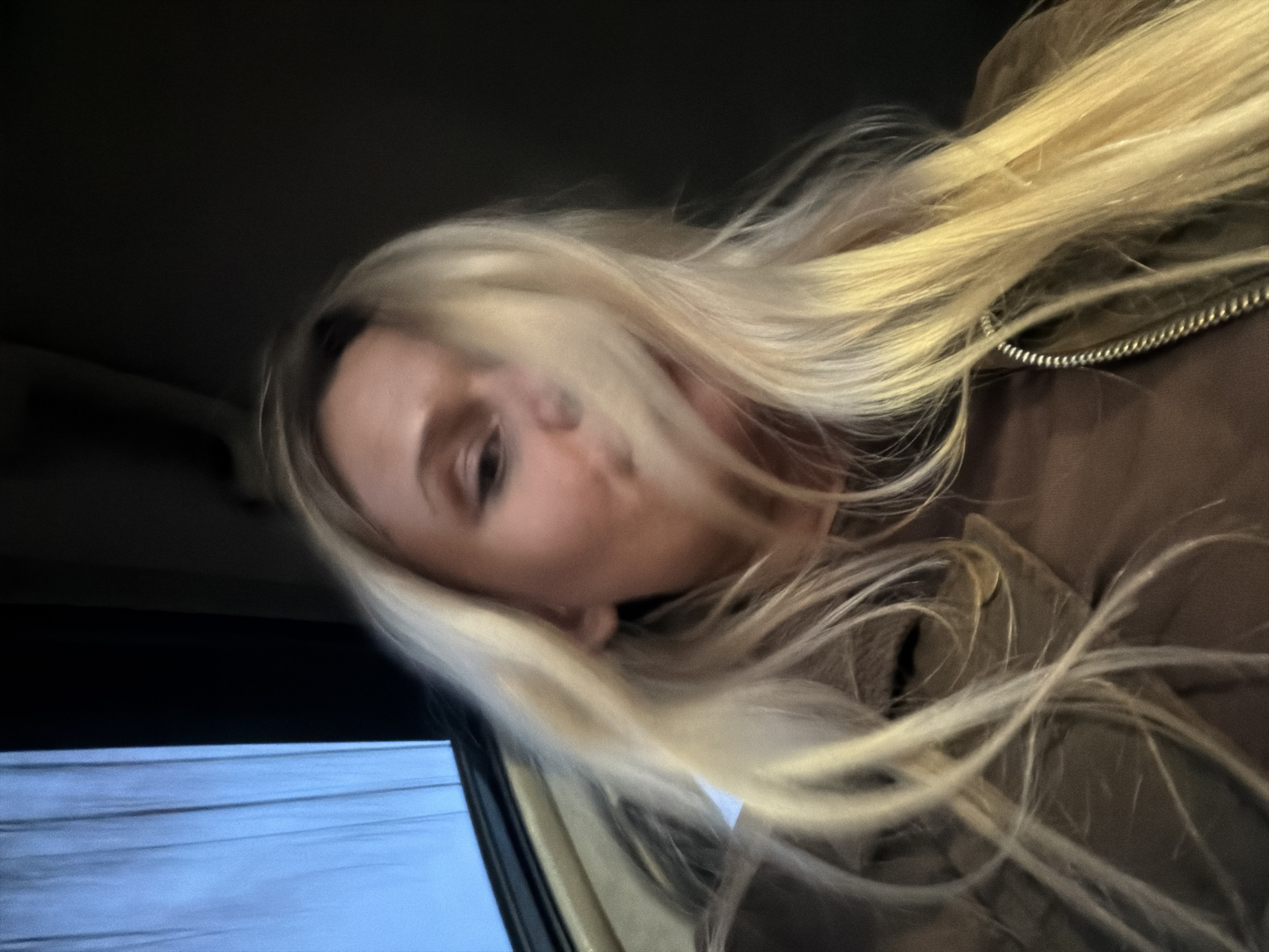 A woman with long, blonde hair is shown in a tilted selfie. She is wearing a brown jacket. The background appears to be the interior of a car at night, as suggested by the dark ceiling and the blurred lights outside the window. The location of Sarapul, Russia is not discernible from the image.
