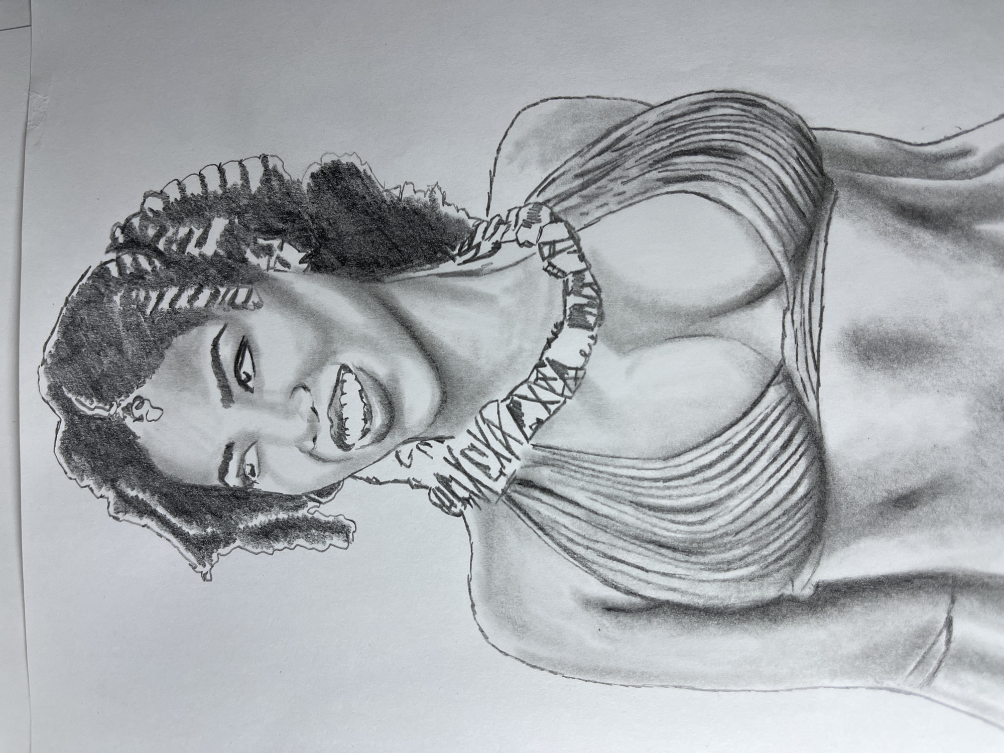 The image is a graphite pencil drawing of a woman with dark, curly hair, smiling broadly. She appears to be wearing a strapless garment with a woven or patterned band around her neck. The drawing captures details of her facial expression, including her teeth, and shading is used to define the contours of her face, body, and clothing. There is no indication of location in the city of Jos, Nigeria.