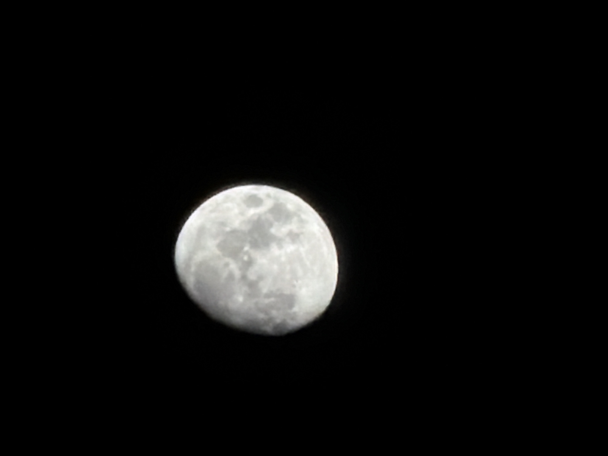 A photograph depicting a waxing gibbous moon set against a black sky. No specific location details relating to Burgas, Bulgaria can be discerned from the image. The moon is on the left side of the image and is almost full with visible craters and lunar surface details. The rest of the image is black, suggesting it was taken at night. There are no other objects, people, or interactions visible.