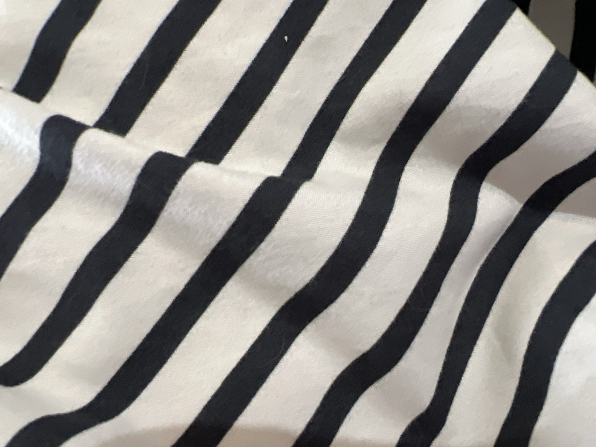 The image shows a close-up of a fabric with black and white stripes. The fabric is folded and wrinkled. There is no information to determine the location as Gradishte, Bulgaria. There are no people, subjects, objects, actions, interactions, or environmental details beyond the fabric itself.