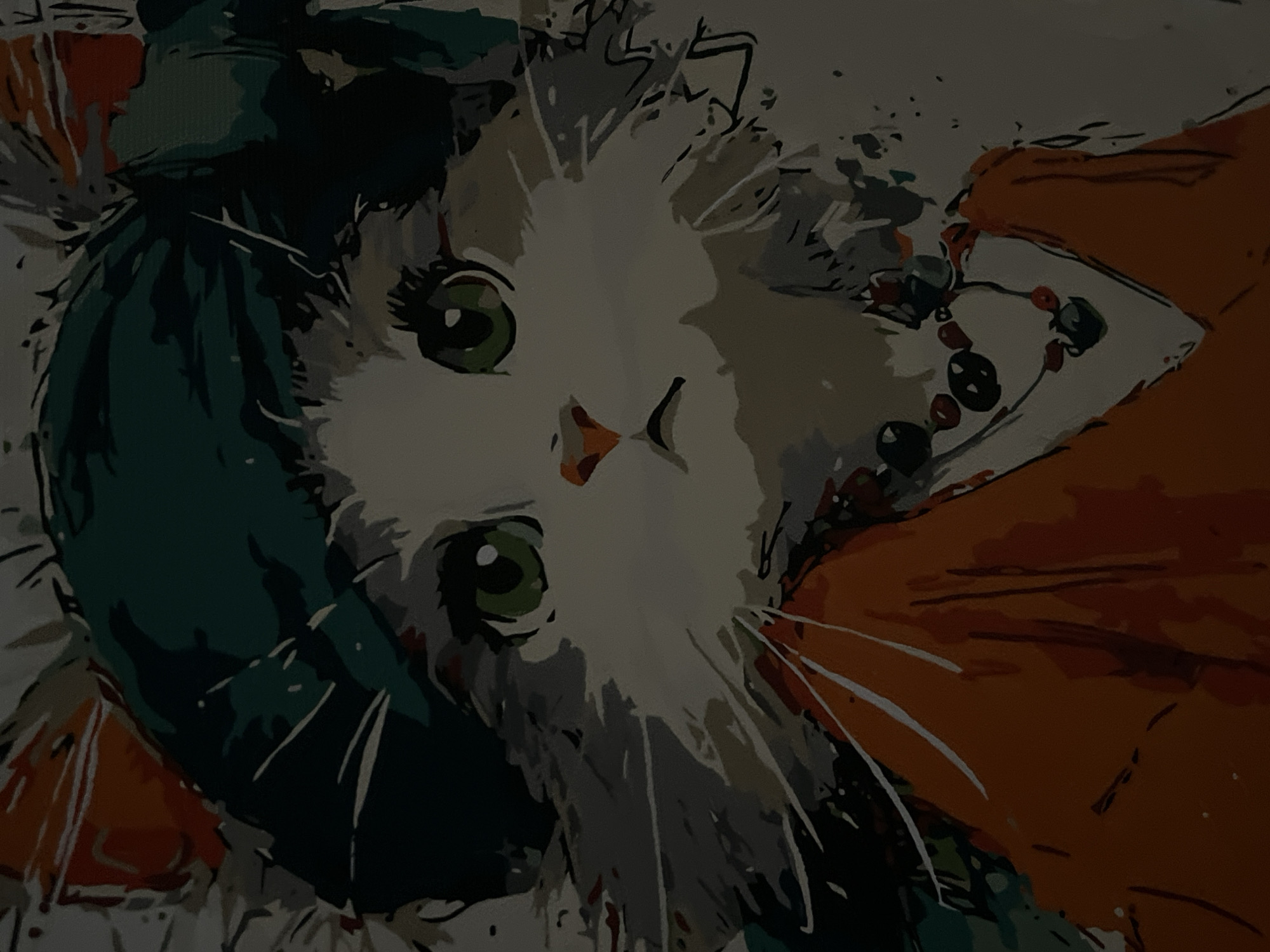 The media file is a painting, likely a digital artwork or a photograph of a painting, featuring a stylized portrayal of a cat. The cat's face is the central focus, with large, prominent green eyes that are looking directly at the viewer. Its fur is depicted in shades of white and grey, with some darker accents. The cat appears to be wearing a dark teal-colored scarf or hood that drapes around its head and neck.
The background is abstract and somewhat chaotic, with splashes of color including orange, dark green, and white. There are also hints of what might be a necklace or beads with dark circular and red elements near the cat's right side. The art style is graphic and somewhat reminiscent of a paint-by-numbers kit, with distinct areas of color and bold outlines.
The lighting in the image is dim, casting a shadowy, moody atmosphere over the painting. The overall impression is one of a close-up portrait of a cat, with a vibrant and slightly disorienting artistic interpretation. There is no visible text within the image itself. The implied context of Lviv, Ukraine, does not provide any specific visual cues within the artwork itself.