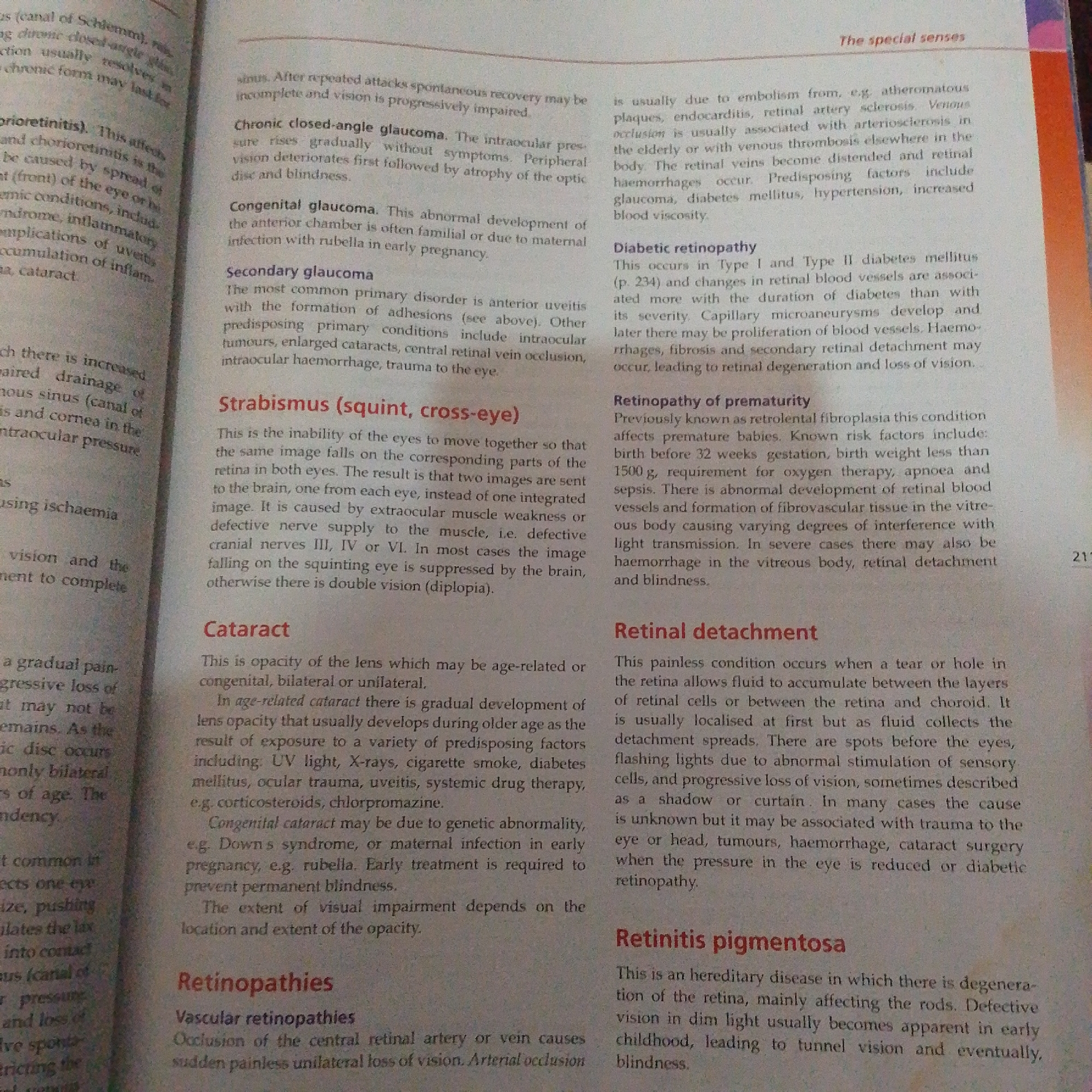 This is a close-up, top-down, slightly angled photograph of an open book. The book is open to a page with dense black text printed on white paper, organized into several paragraphs and headings. The page is well-lit and clear, with no visible signs of damage or distortion. The content of the text appears to be medical or scientific in nature, discussing various eye conditions such as glaucoma, cataracts, and retinopathies. There are no people or objects other than the book visible in the frame. The background is out of focus, but appears to be a plain, light-colored surface. The image does not provide any information about a city, location, or geographical context.