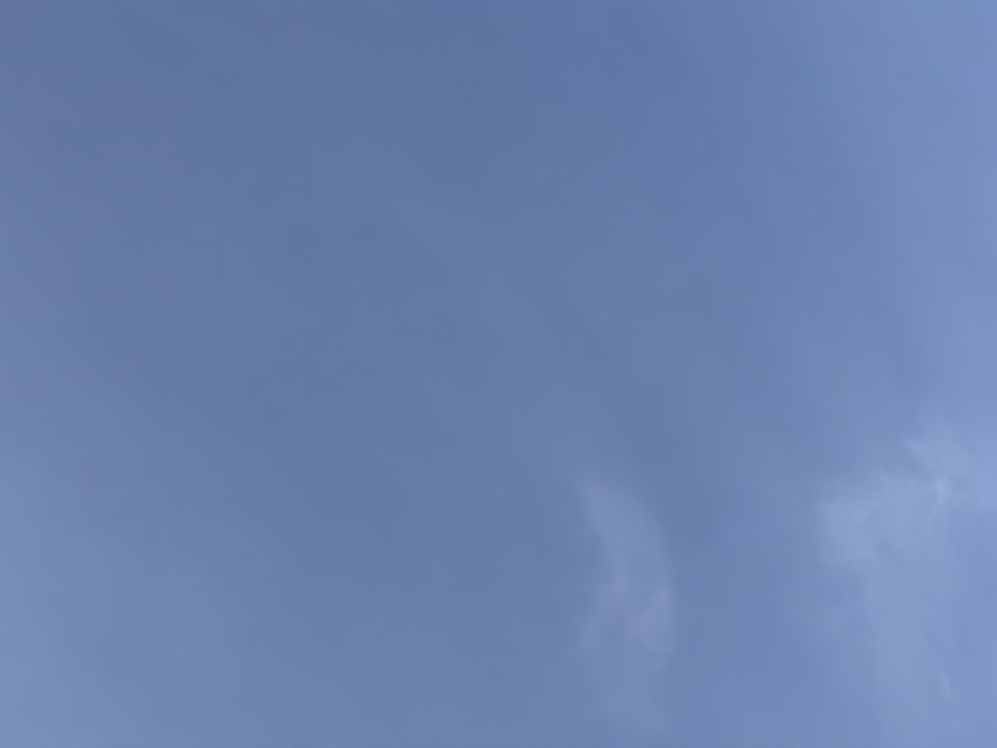 The image shows a pale blue sky with wispy, indistinct clouds in the lower right corner.