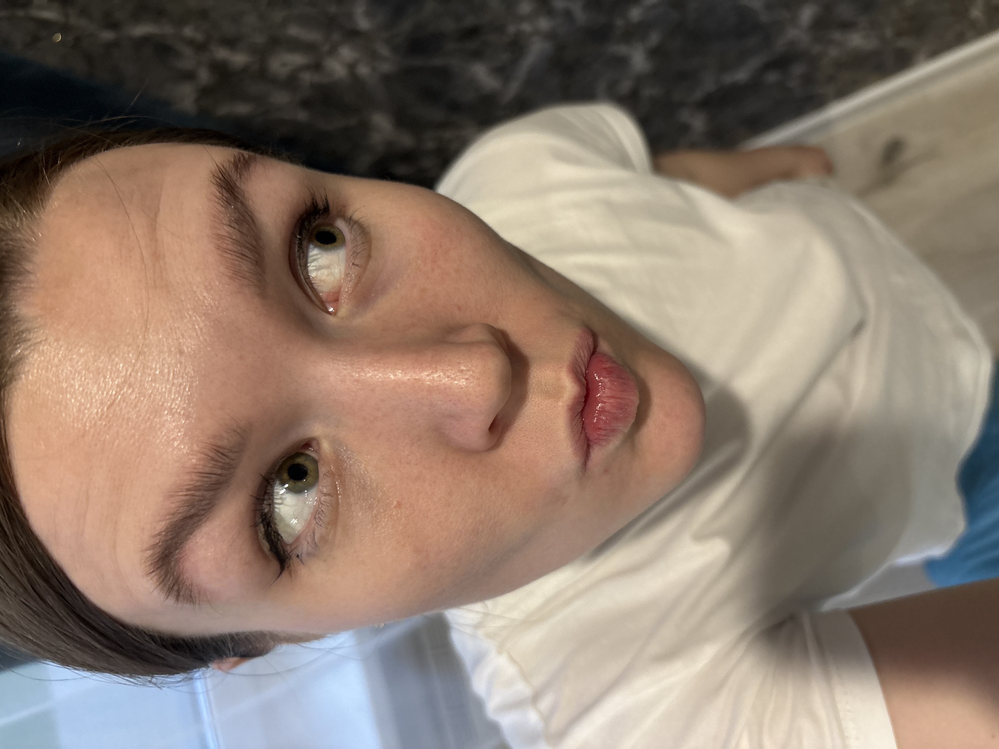 A selfie of a light-skinned person with dark hair, eyes looking upwards at the camera, lips pursed, and wearing a white t-shirt. The background is blurred.
I am unable to pinpoint a specific location, much less one within Izhevsk, Russia.