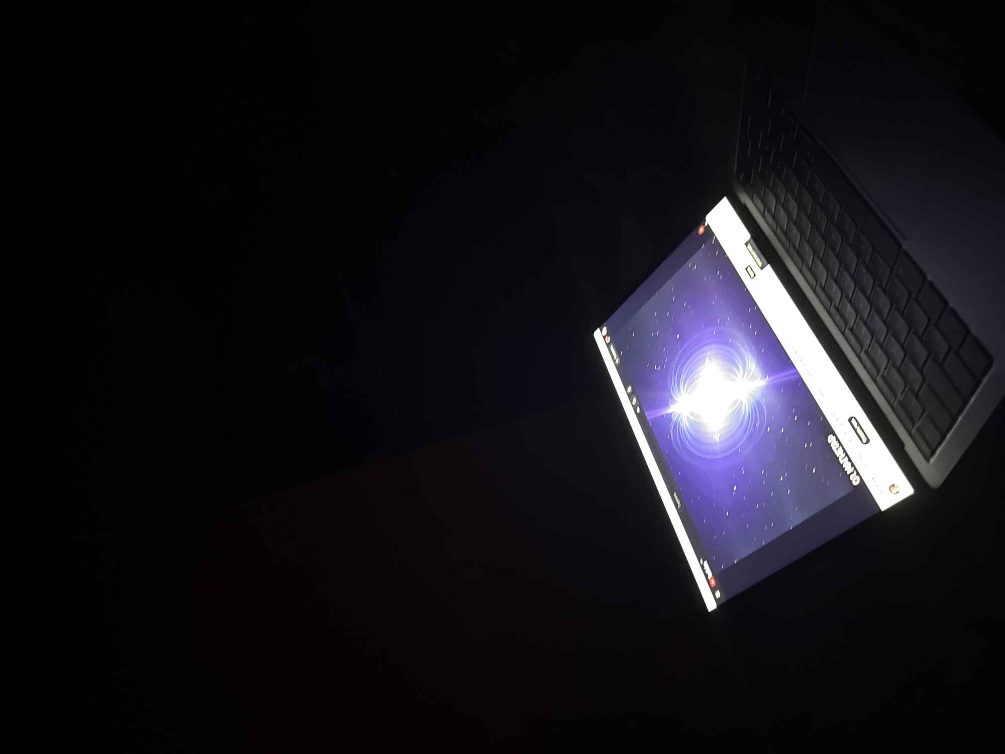 The image shows a laptop with its screen illuminated, displaying a science-themed video with a purple background and a bright, central light source, possibly representing a nebula or star. The laptop is open and placed on a dark surface, with part of its keyboard visible. The surrounding environment is dark, suggesting the photo was taken in low-light conditions. The screen also shows a portion of the YouTube interface, including the channel name "OR MATHEMATIC" and a "SUBSCRIBE" button. The scene is captured from an angle, focusing on the laptop and its screen. The image does not provide any information or visual cues to determine a specific location in the city of Plovdiv, Bulgaria.